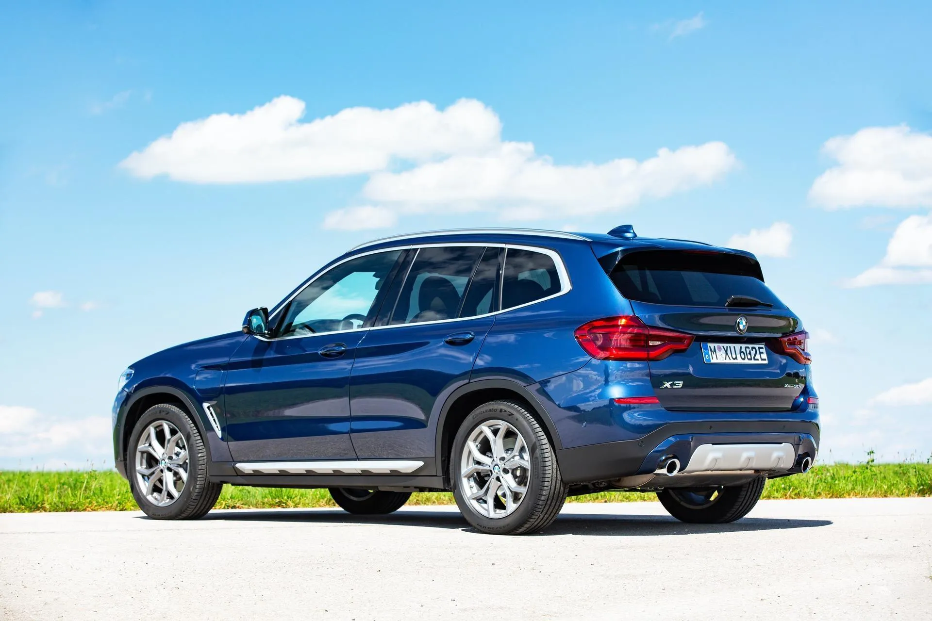 Blue Bmw Parked on Grass with Clear Sky in the Background