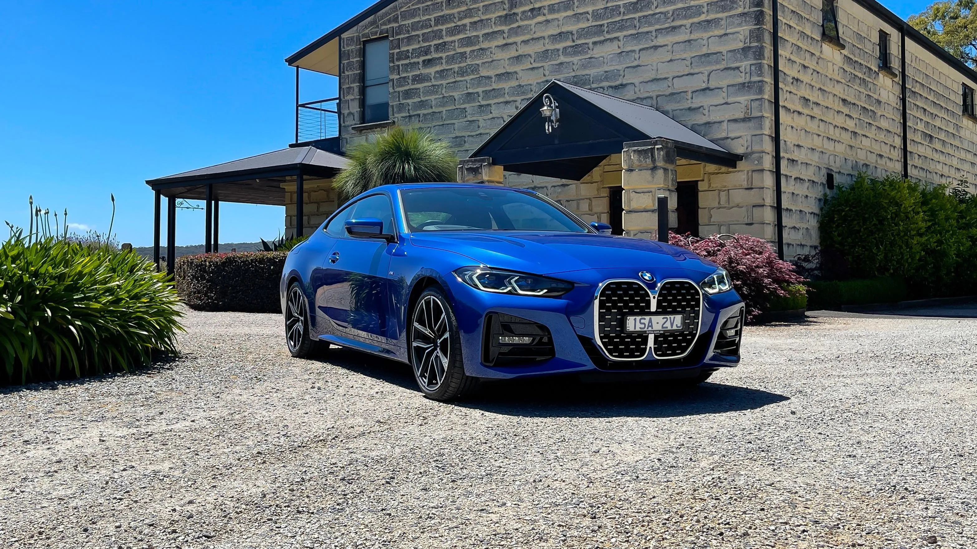 Blue Bmw Parked on Gravel Driveway Next To a Modern House