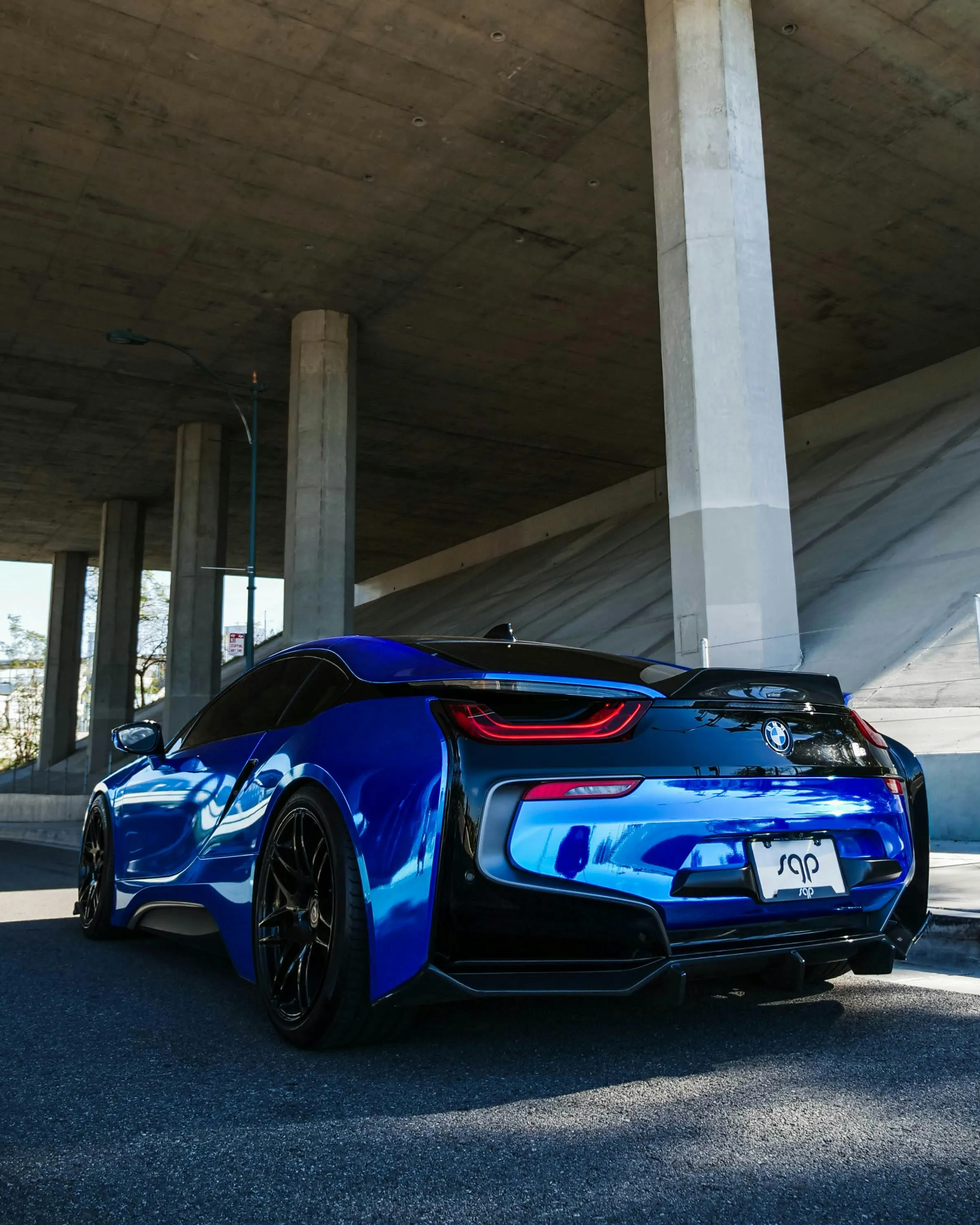 Blue Bmw Parked Under Bridge Casting Long Clean Shadows