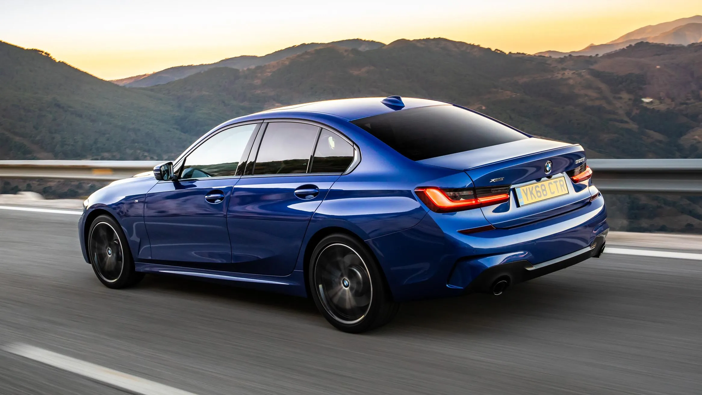 Blue Bmw Sedan Driving on a Mountain Road Wallpaper