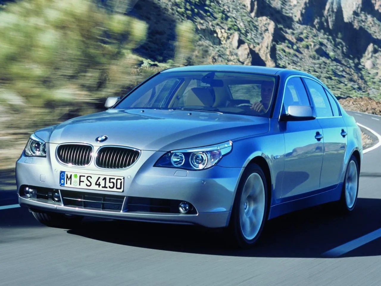 Blue Bmw Sedan Driving on Open Road with Clear Sky