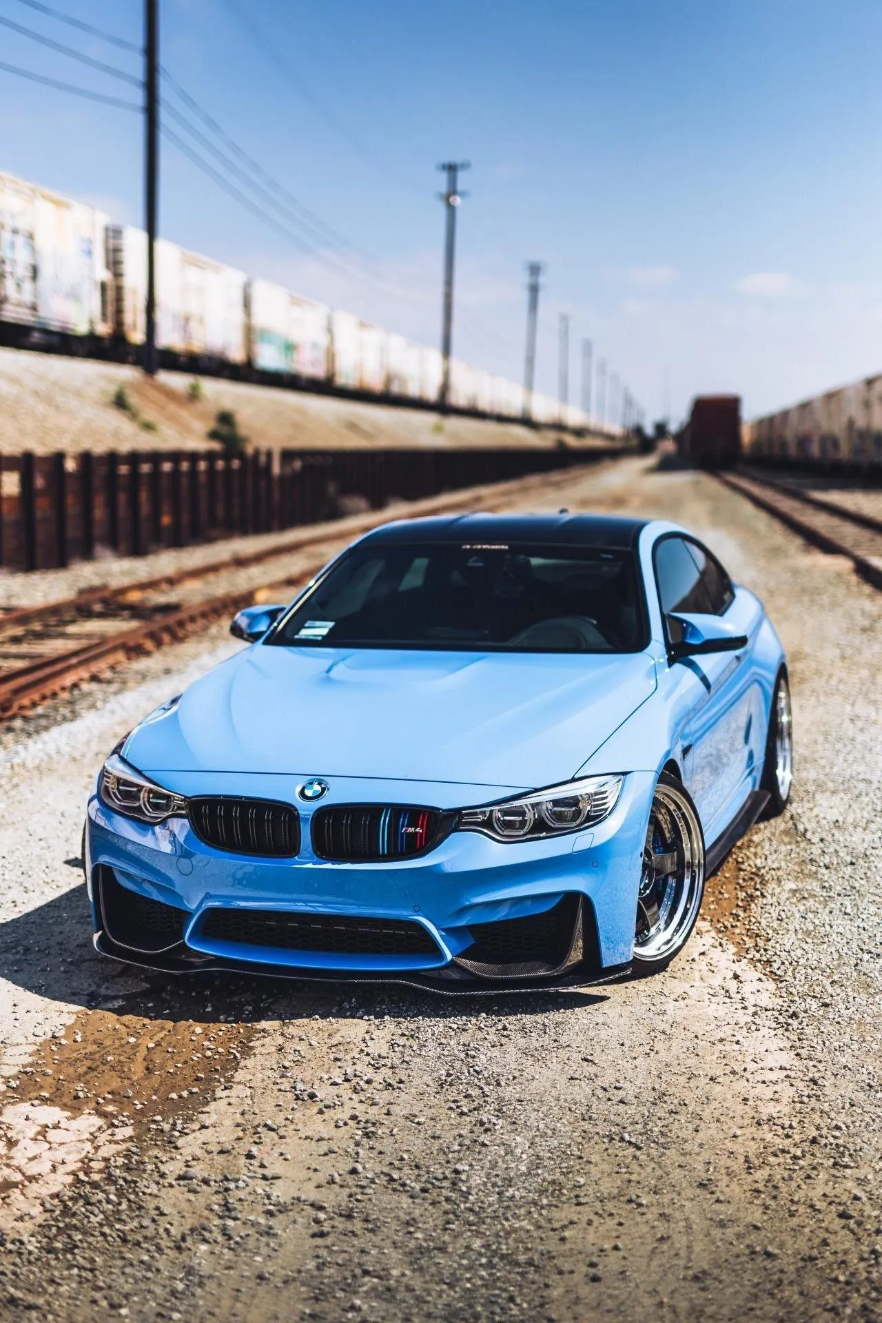 Blue Bmw Sedan on Dusty Ground Near Railway Tracks Hd Image