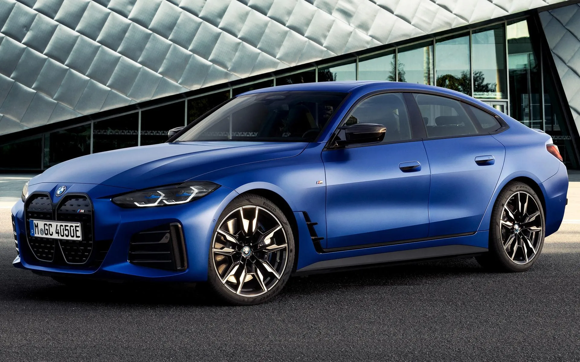 Blue Bmw Sedan Parked in Front of Modern Glass Building