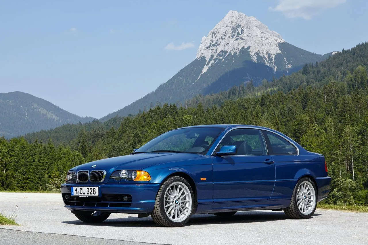 Blue Bmw Sedan Parked on Mountain Road with Clear Sky