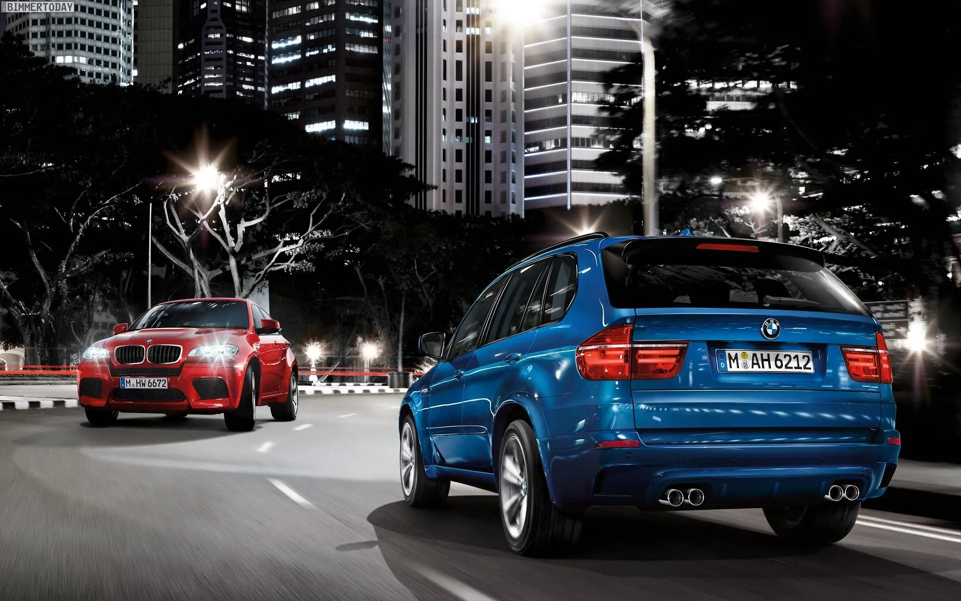 Blue Bmw Suv Driving at Night in City with Tall Buildings