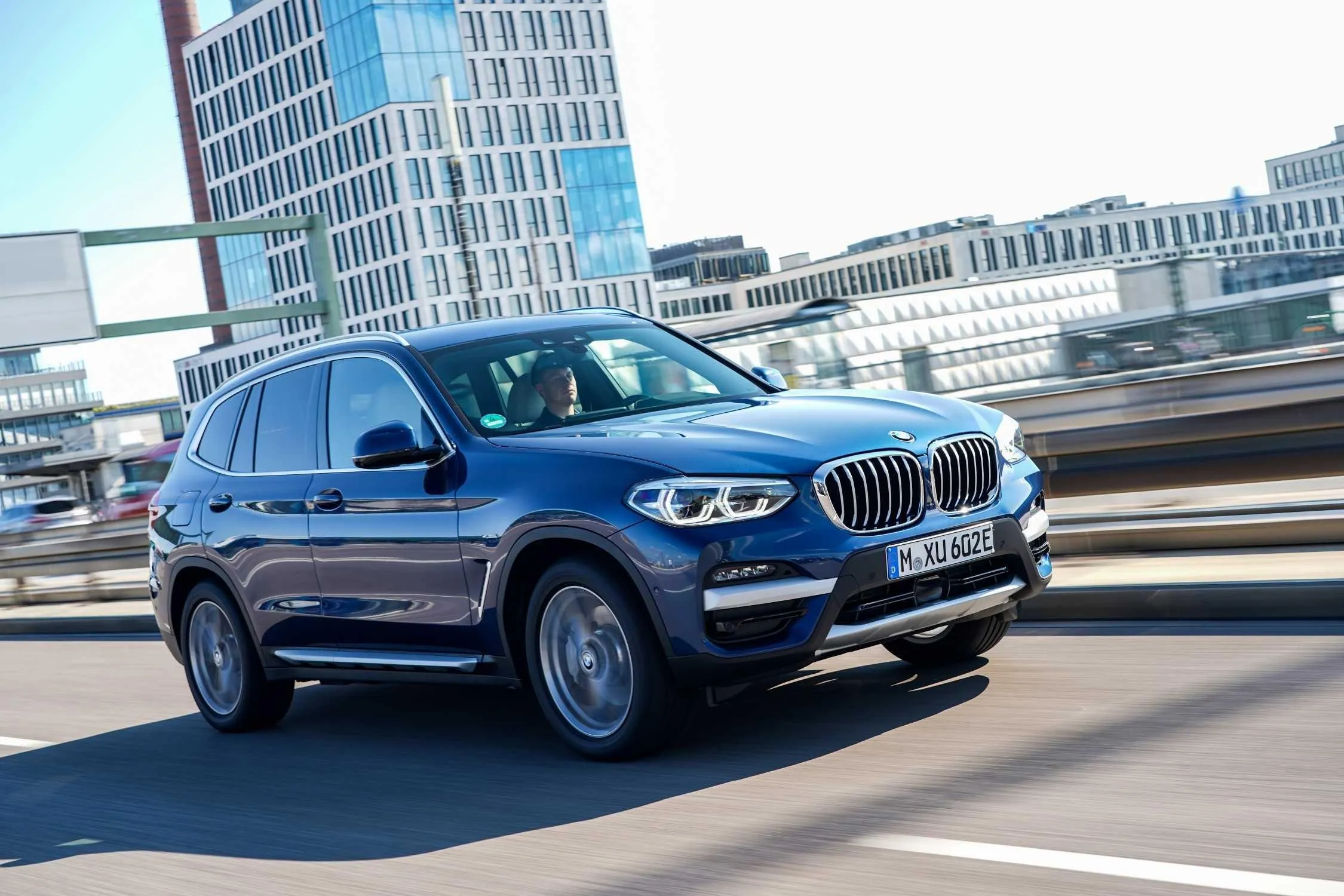 Blue Bmw Suv Driving in City with High Rise Buildings