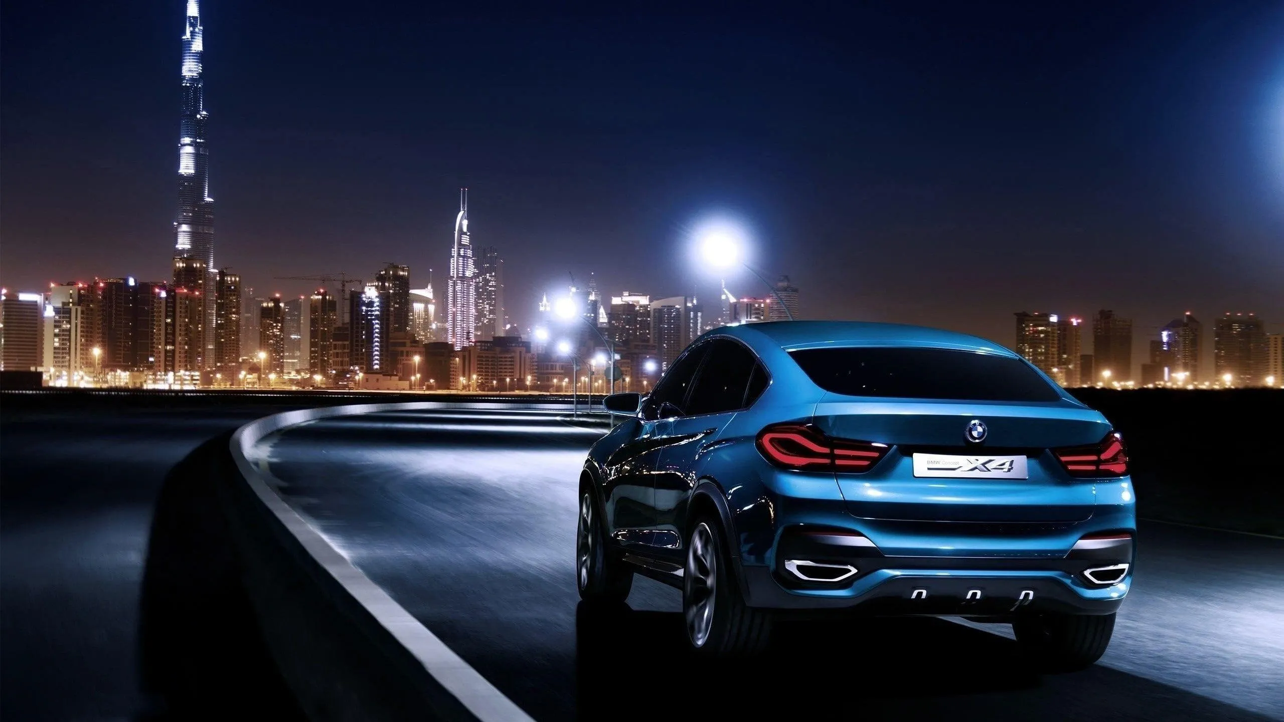 Blue Bmw Suv Overlooking City Skyline at Night Time
