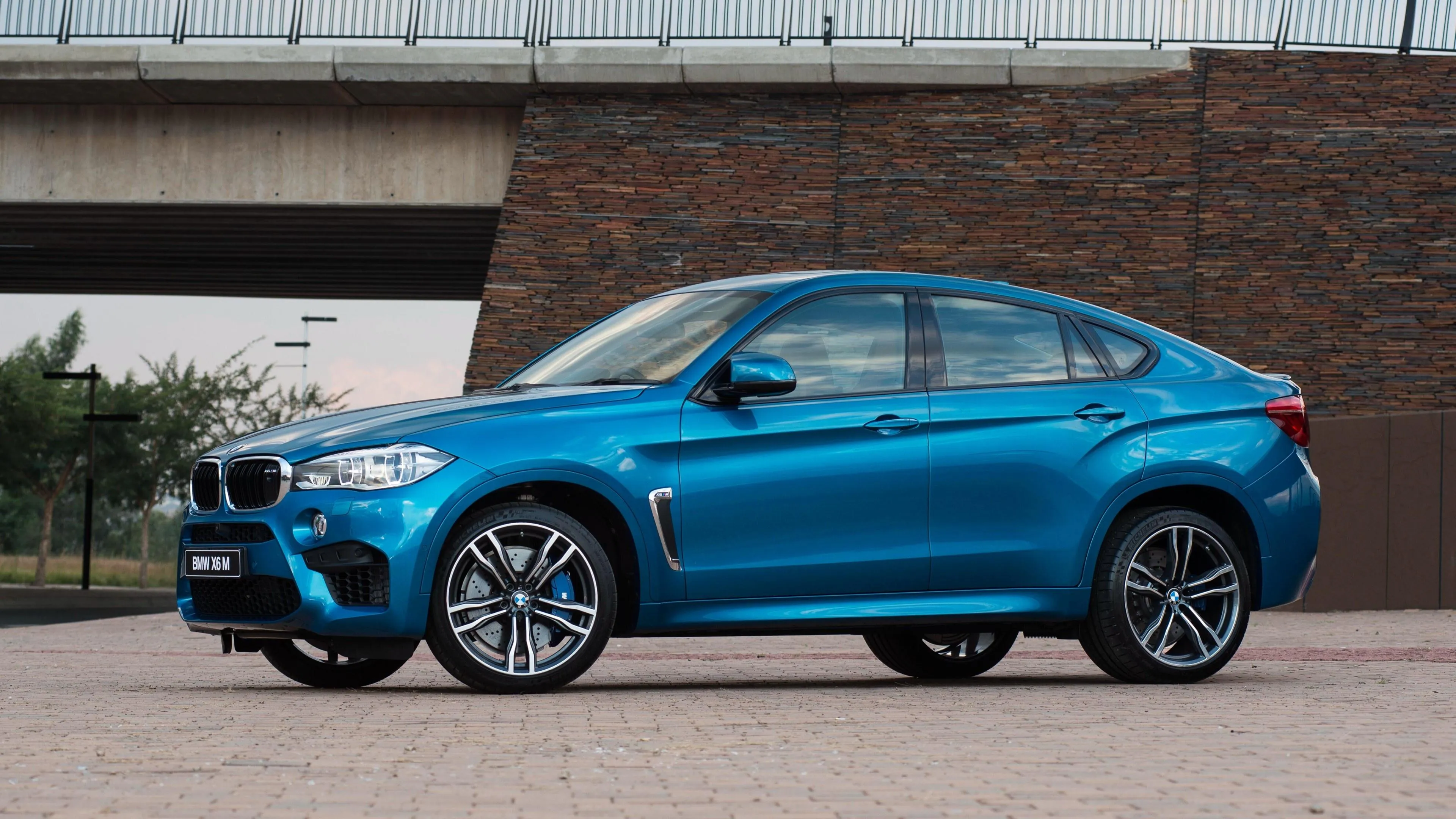 Blue Bmw Suv Parked in Front of Red Brick Modern Building