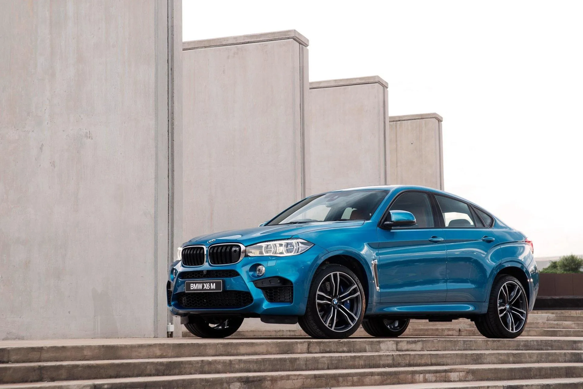 Blue Bmw Suv Parked Near Modern Concrete Walls Wallpaper