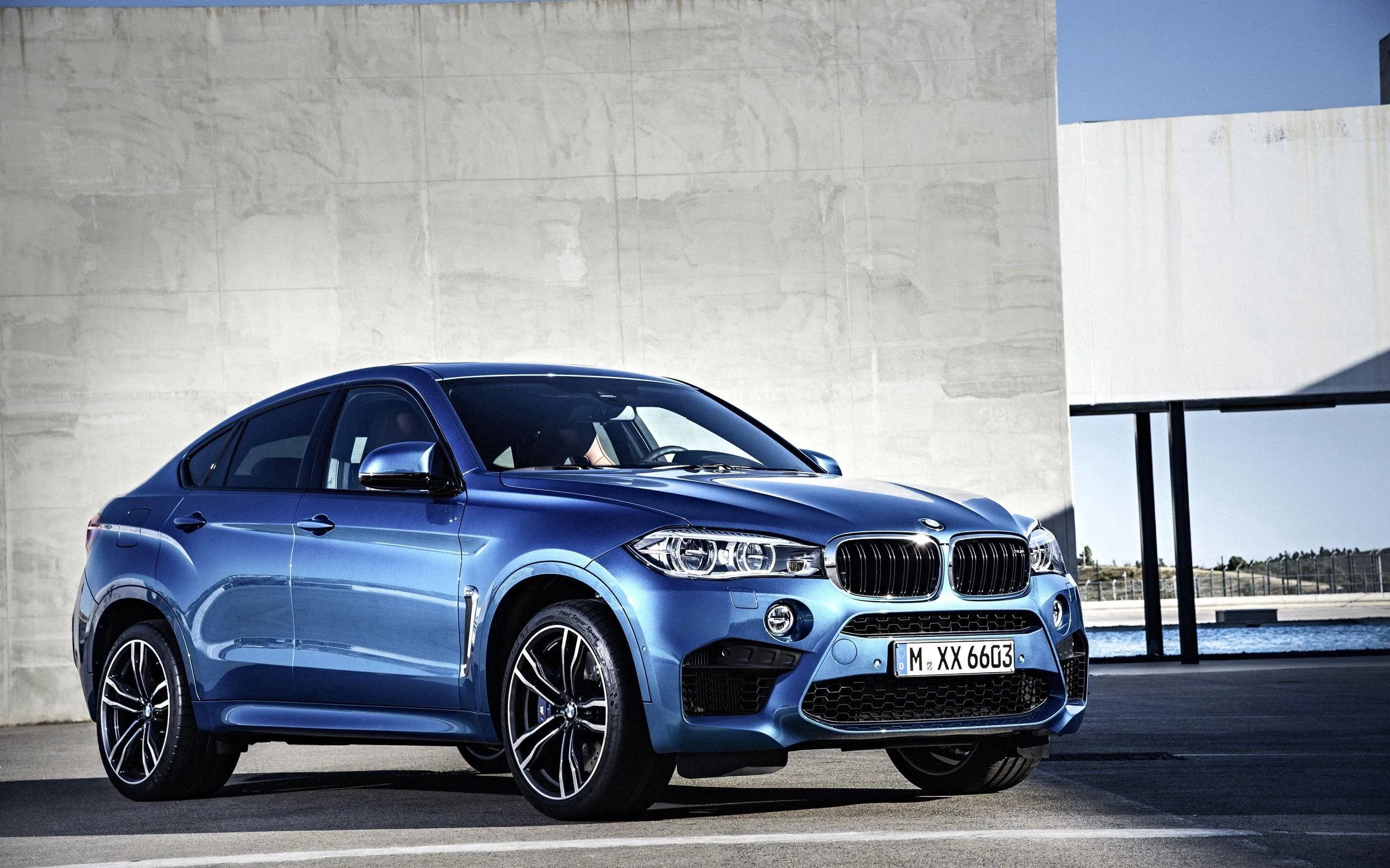 Blue Bmw Suv Parked on Concrete By Industrial Site Image