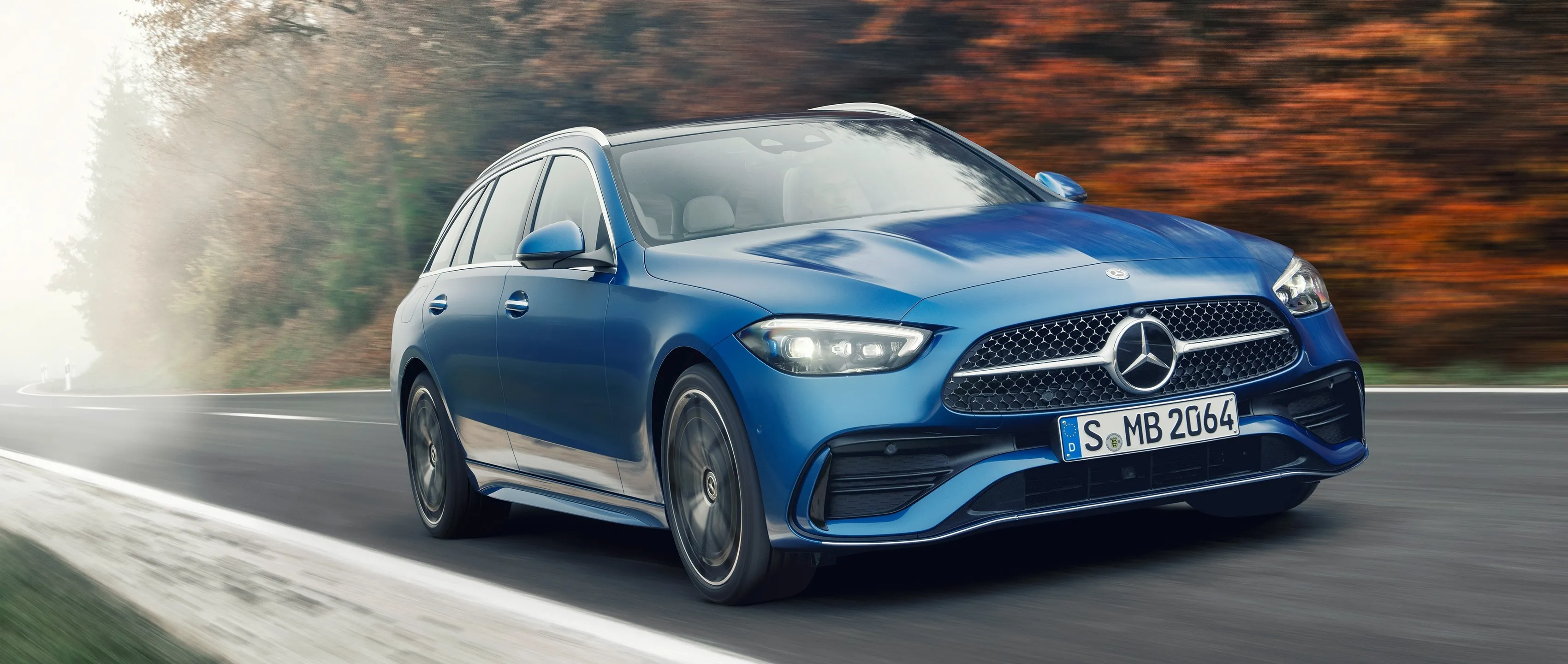 Blue Mercedes Benz Sedan Driving Through Autumn Forest
