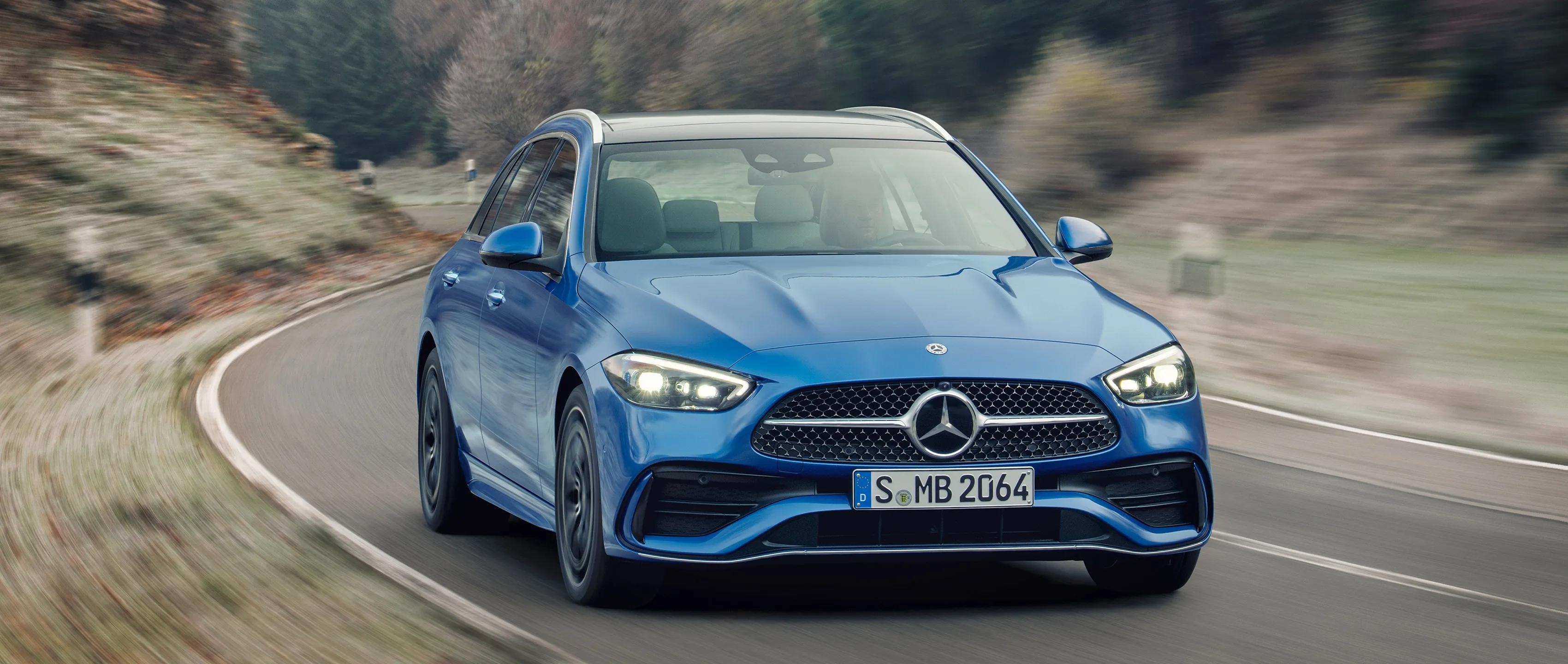 Blue Mercedes Benz Sports Sedan Driving on Curvy Road