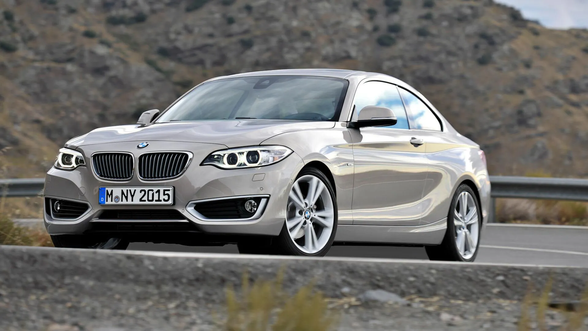 Bmw 2 Series Driving Through a Dry Rocky Landscape Image