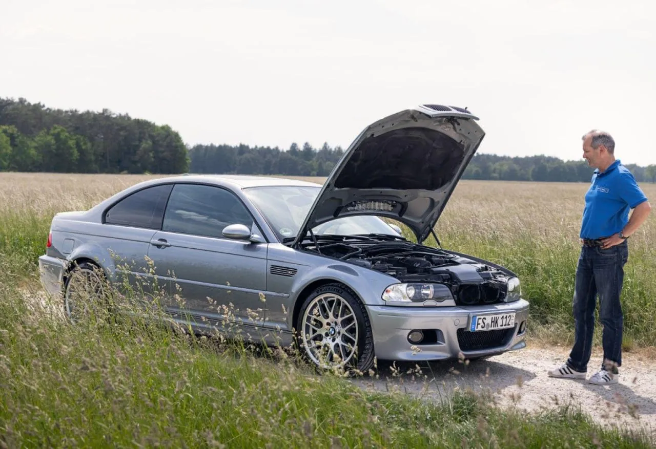 Bmw Car Being Checked By Mechanic on a Grassy Field