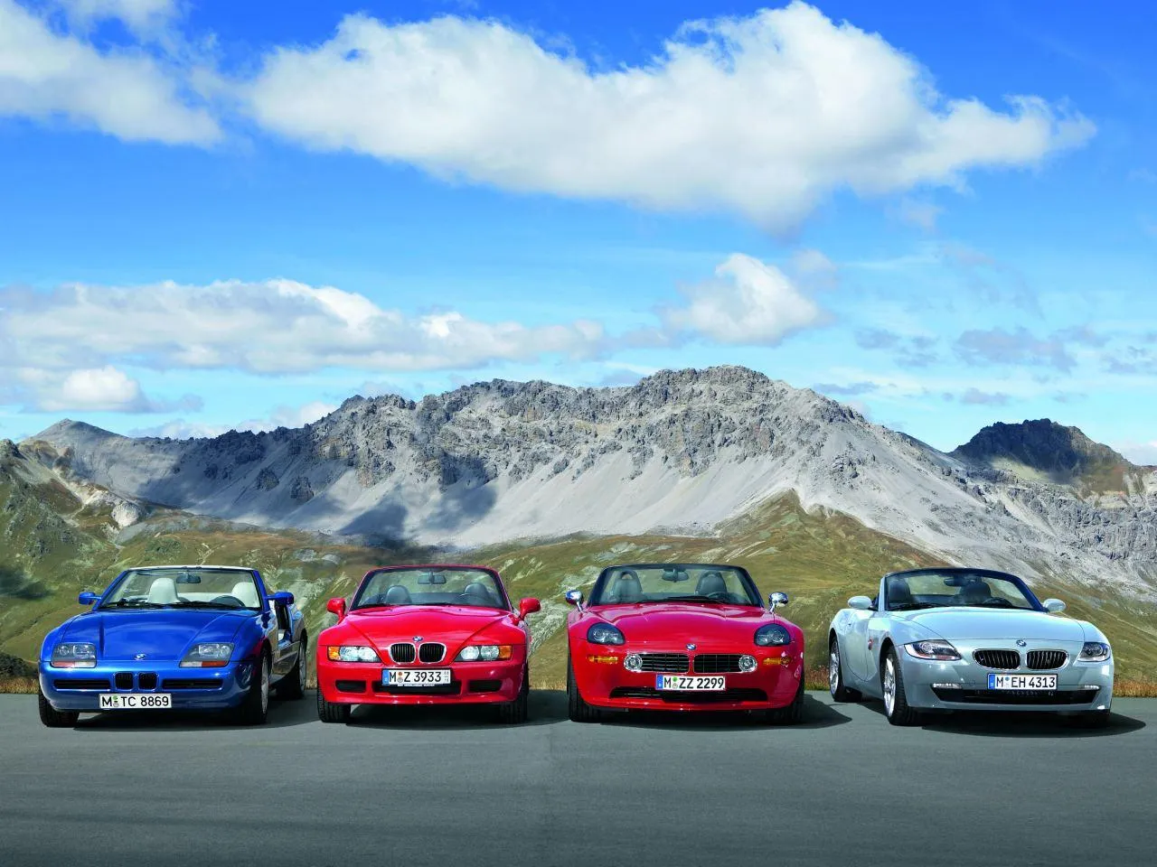 Bmw Cars in Various Colors Lined Up on a Mountain Road