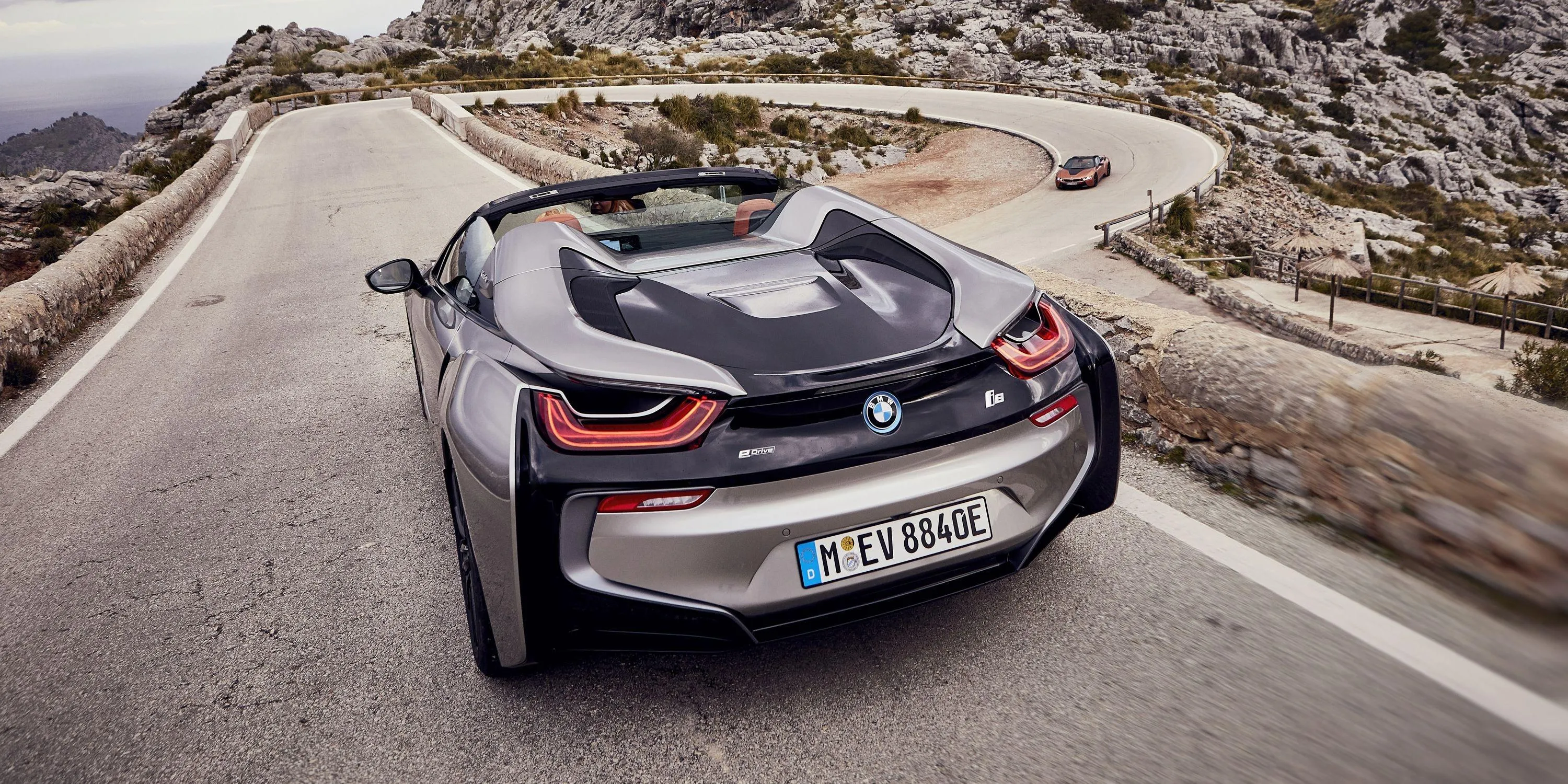 Bmw Convertible Driving on Empty Mountain Road Wallpaper