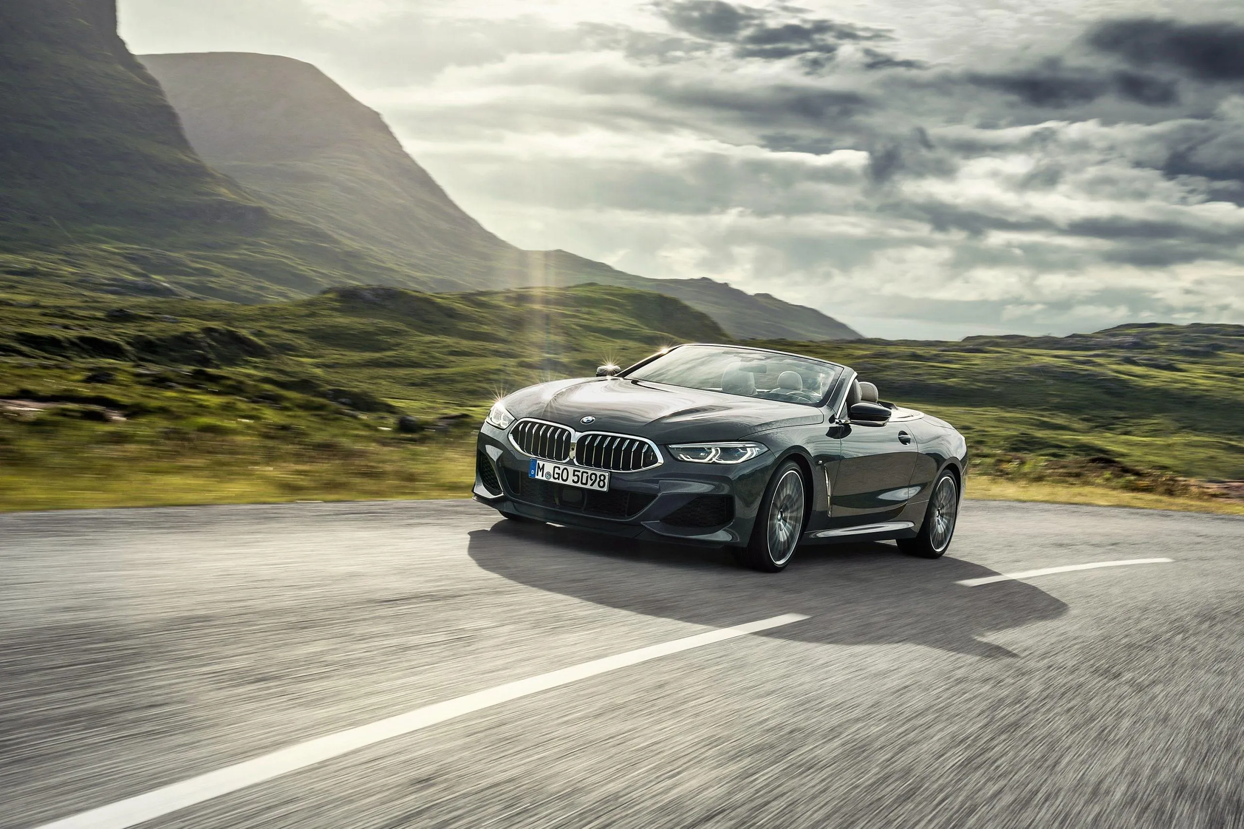 Bmw Coupe Driving Down Scenic Open Country Road Wallpaper