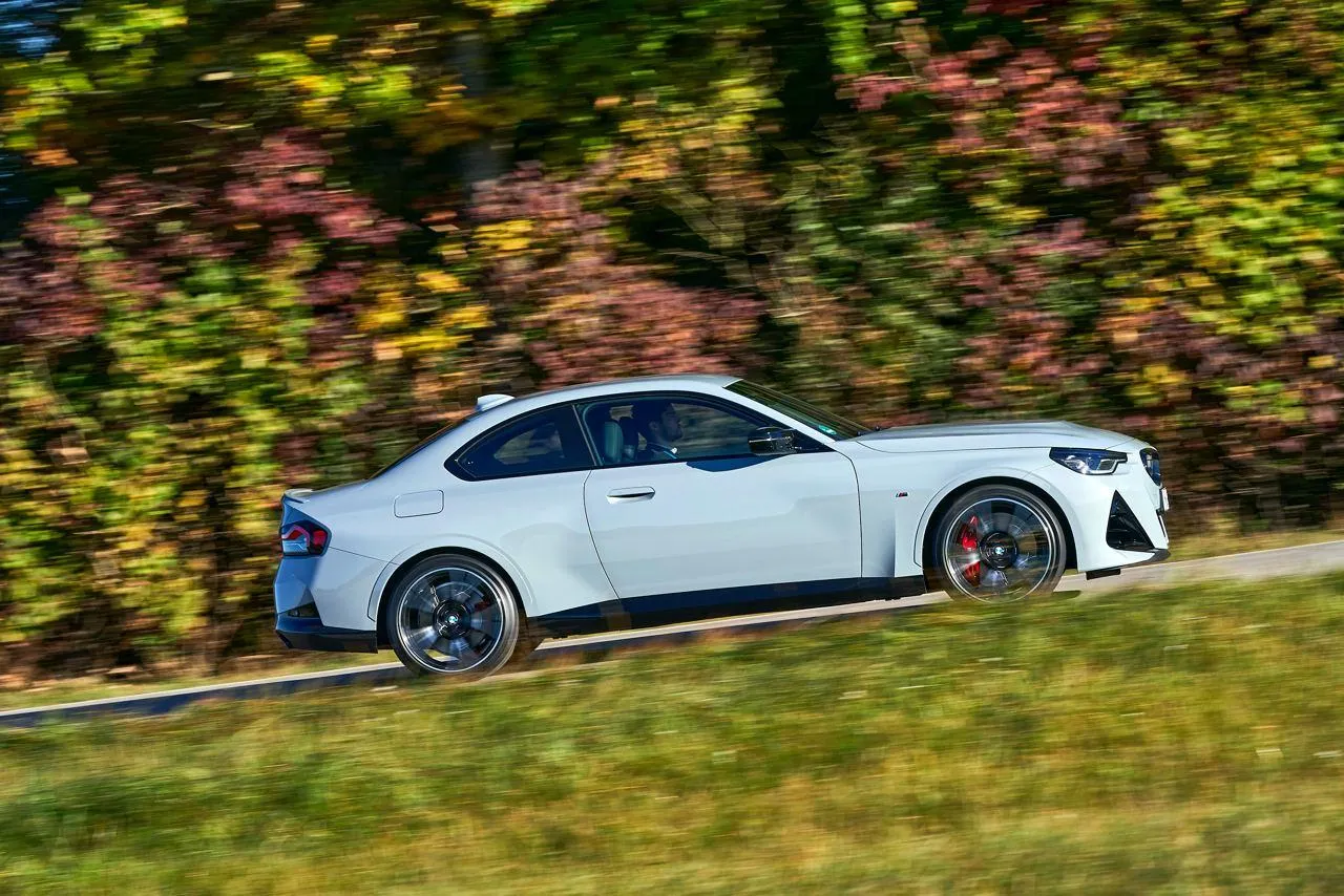 Bmw Coupe Speeding Down a Curvy Road Surrounded By Nature