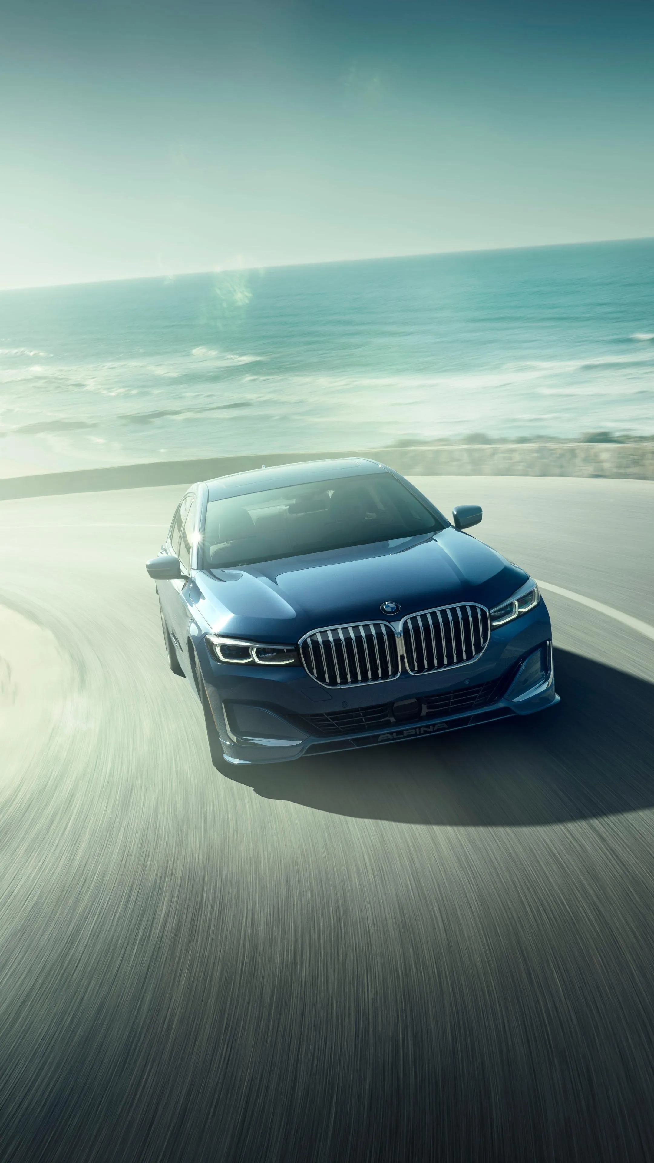 Bmw Driving Fast on Sandy Beach with Ocean Waves Wallpaper