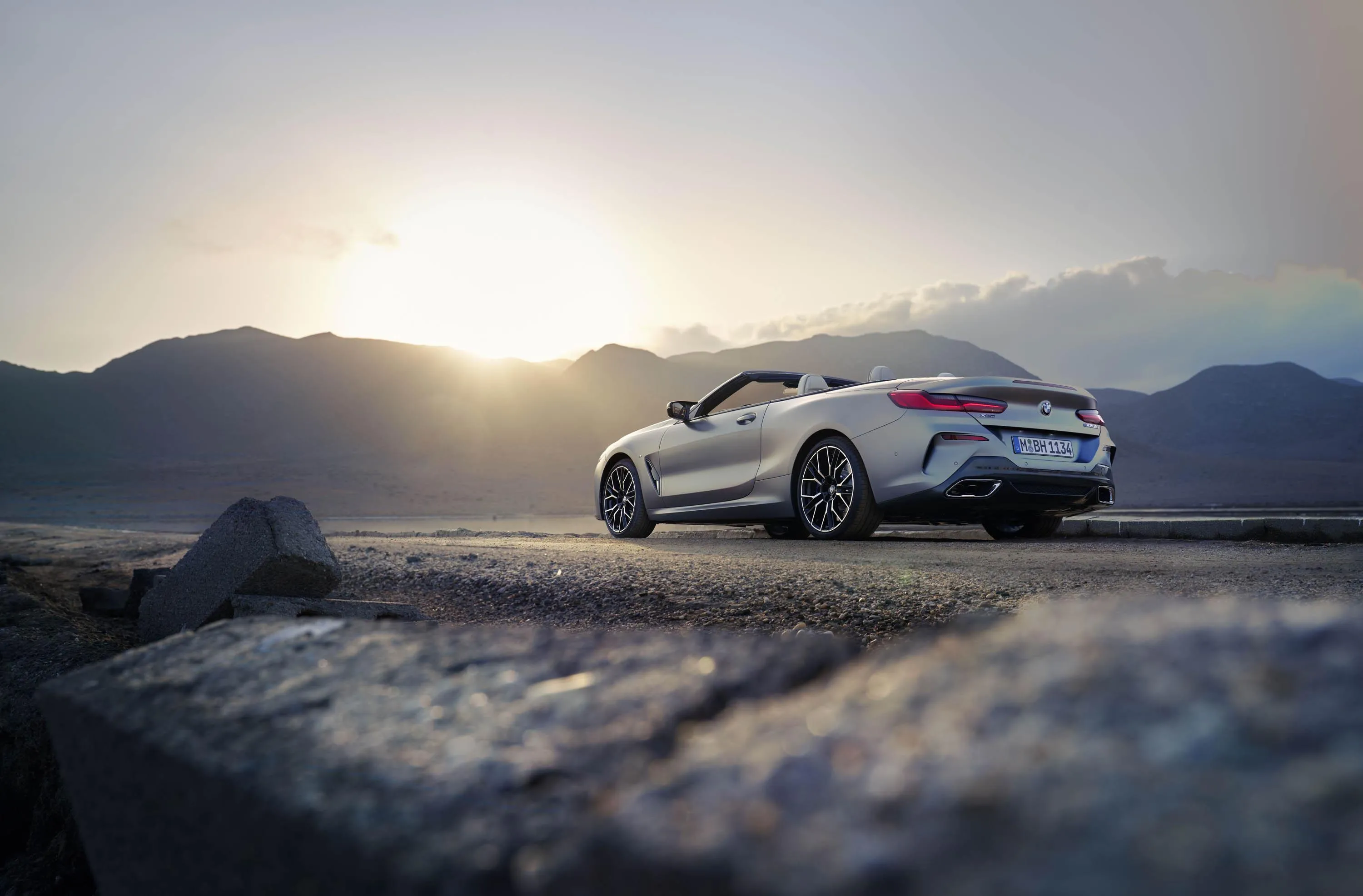 Bmw Driving on Rocky Coastline Under Evening Sky