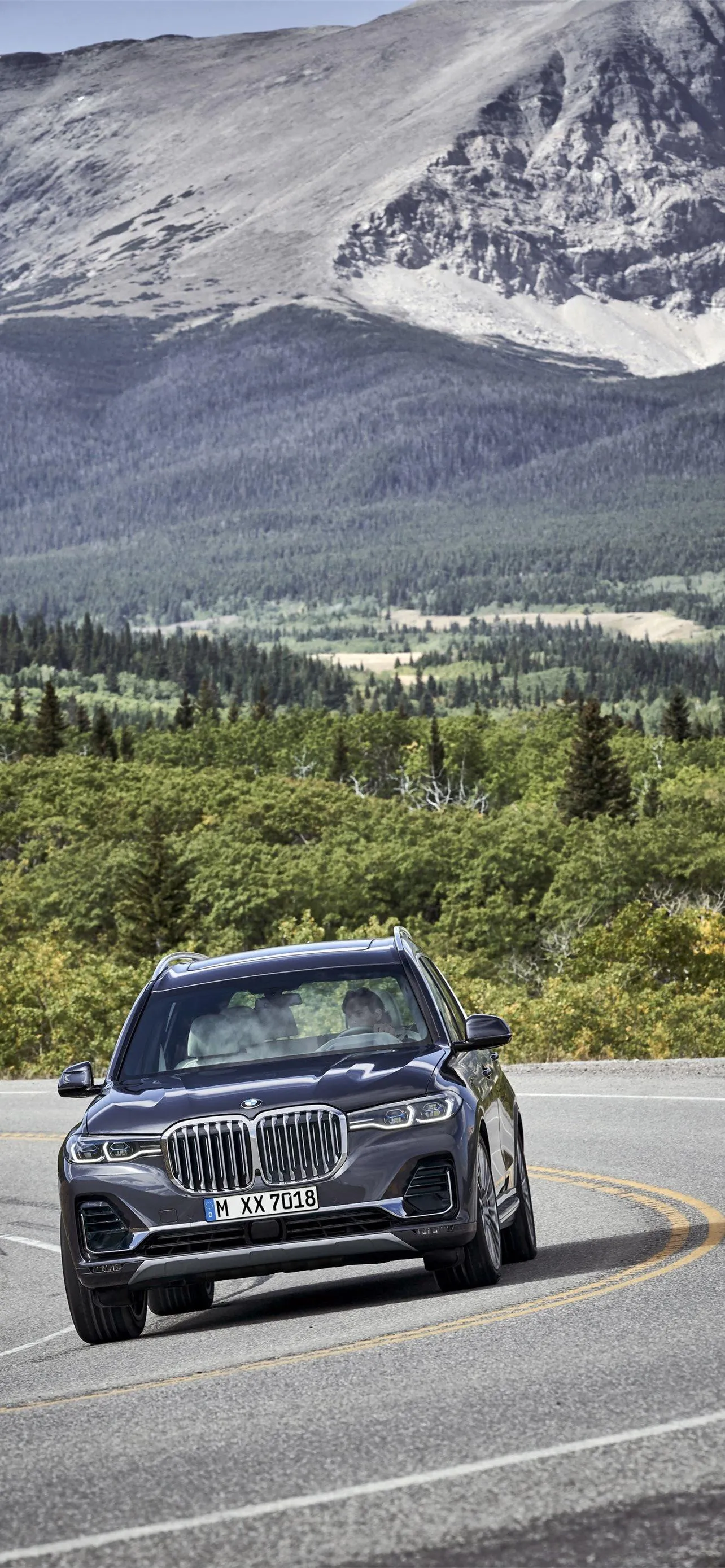Bmw Driving Through Mountain Valley on a Clear Day