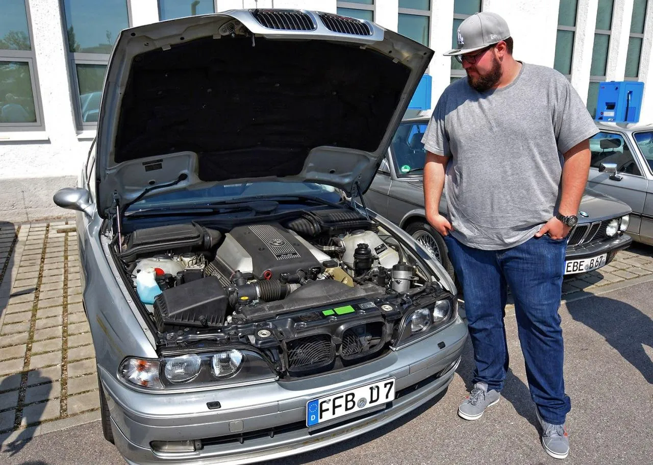 Bmw Engine Being Inspected By Men in Casual Outfits Image
