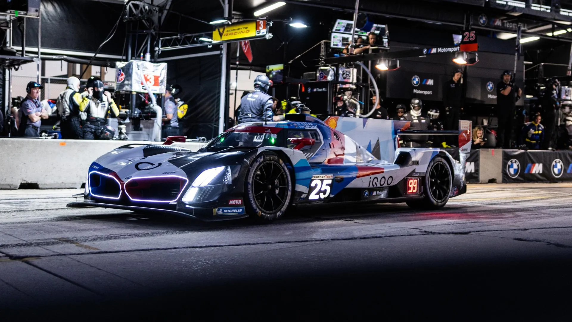 Bmw Formula One Race Car in Pit Garage Under Lights
