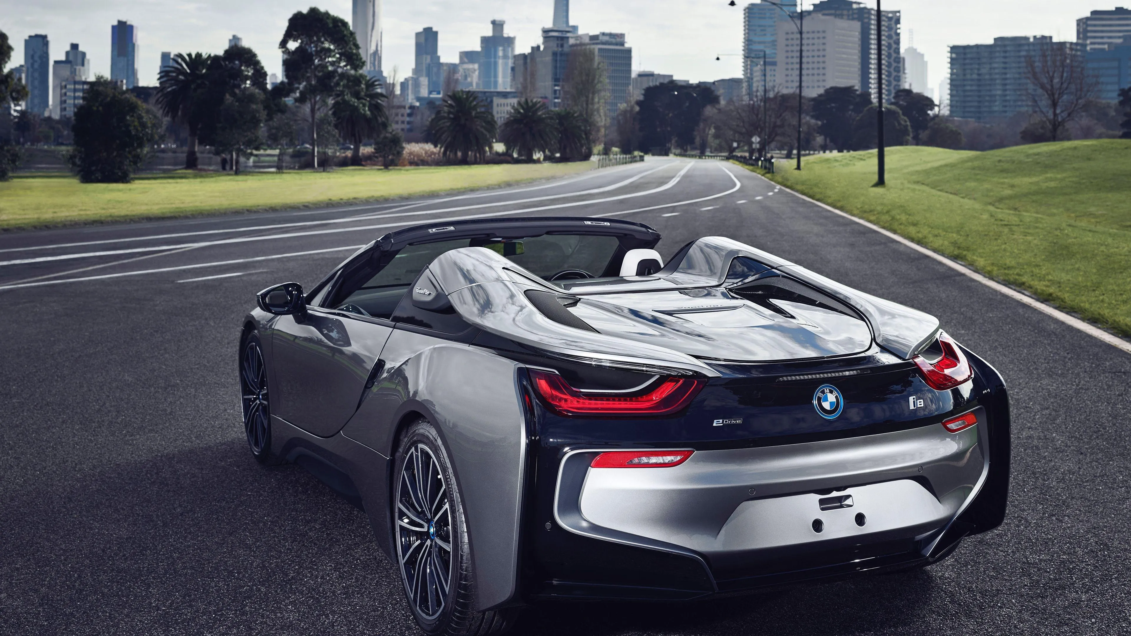 Bmw I8 Driving on Urban Road Near Buildings and Trees