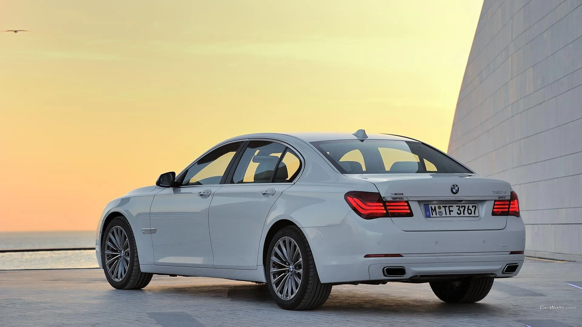Bmw Luxury Sedan Parked on a Beachside with Elegant Sunset