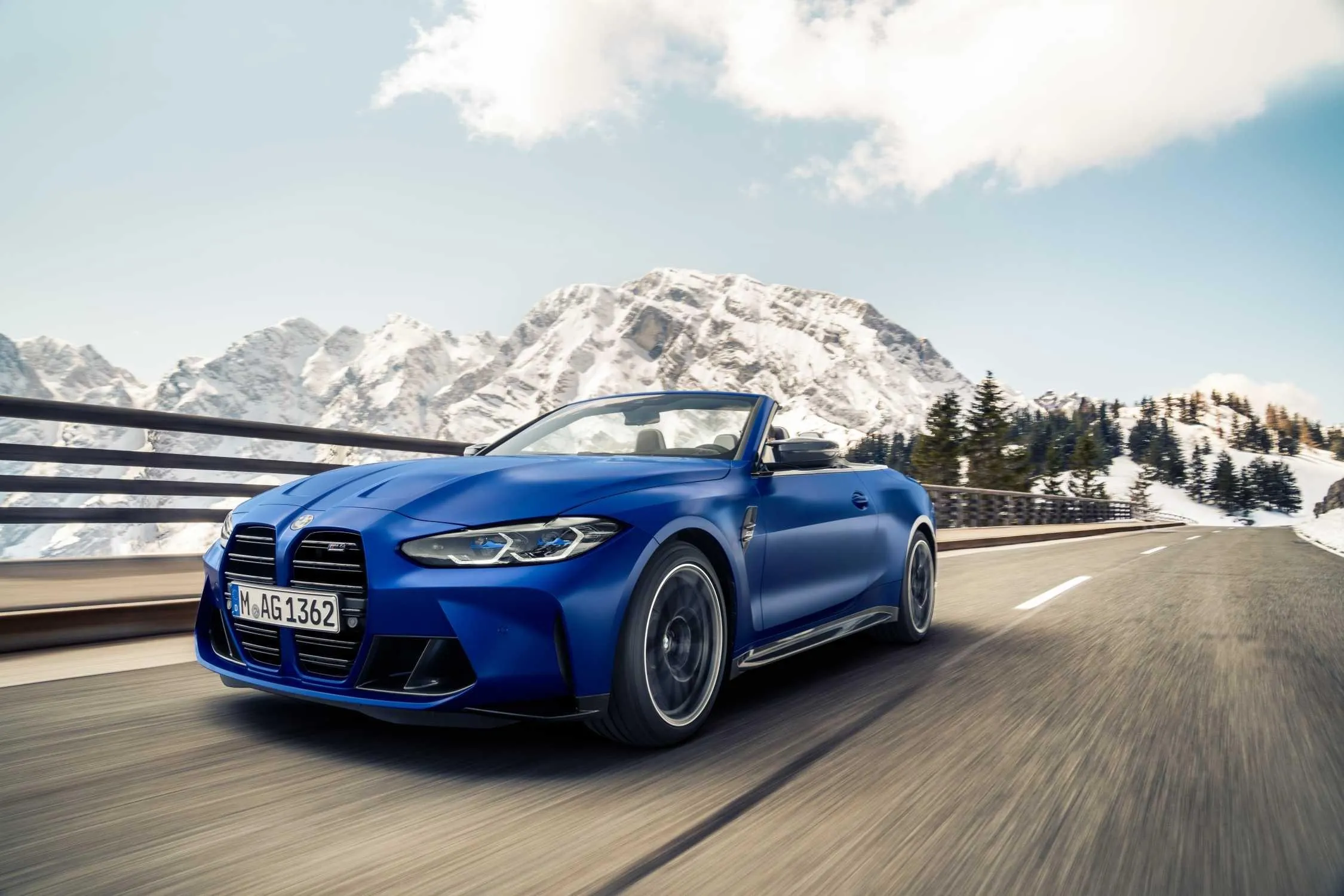 Bmw M4 in Blue Driving Along a Snowy Mountain Road