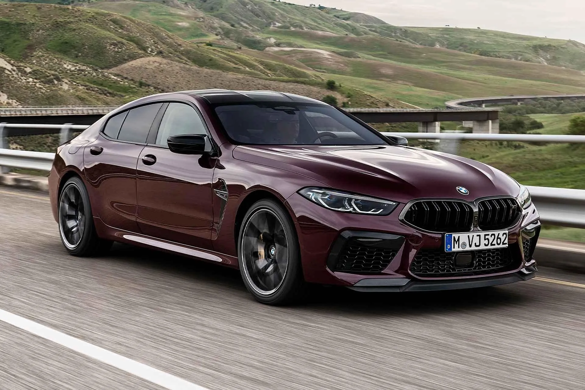 Bmw Maroon Sports Car Driving on Mountain Road Image