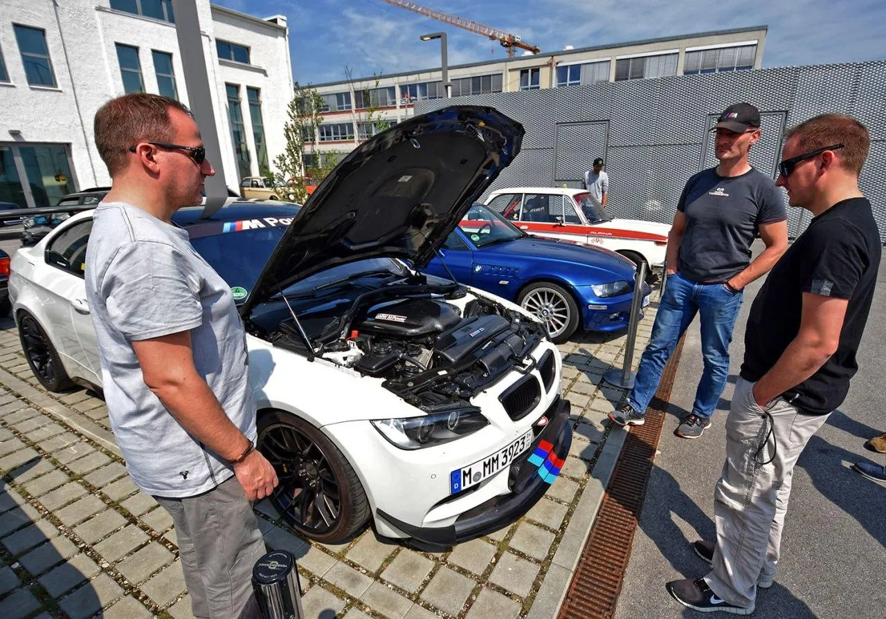Bmw Mechanics Inspecting Engine at Outdoor Garage Image