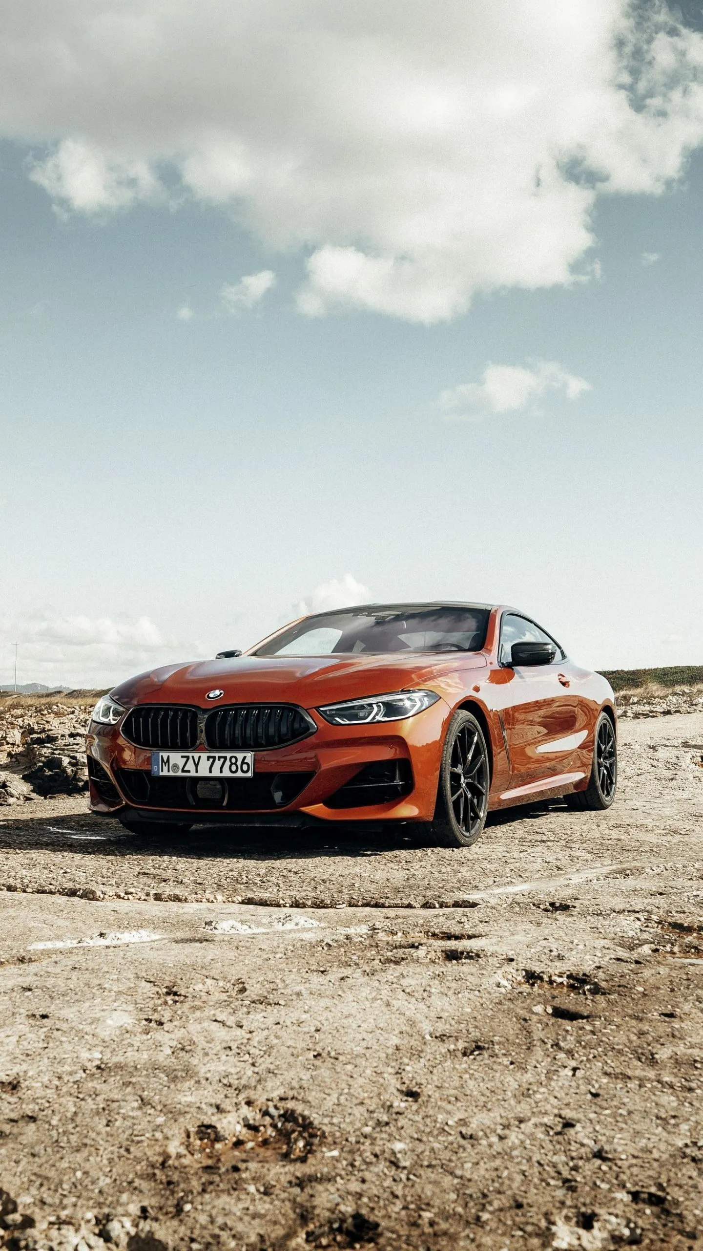 Bmw on Dry Rocky Terrain Under Bright Partly Cloudy Sky