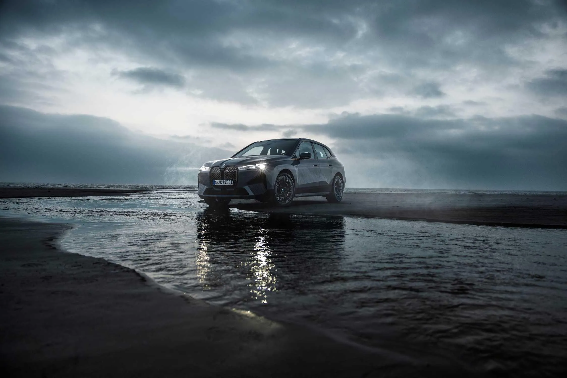 Bmw on Scenic Coastline Road with Dramatic Cloudy Skies