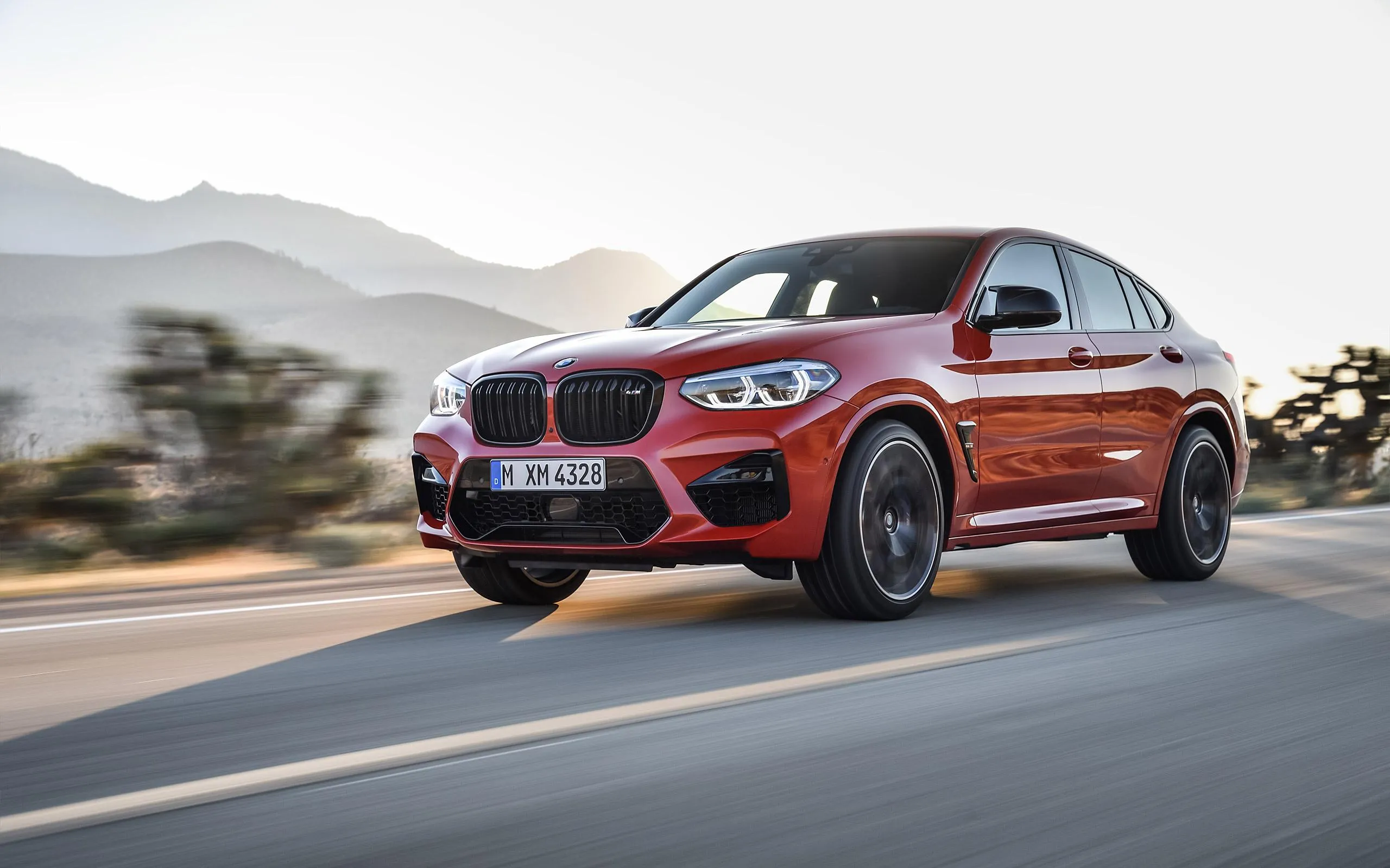 Bmw Orange Suv Driving on Road with Mountains Wallpaper