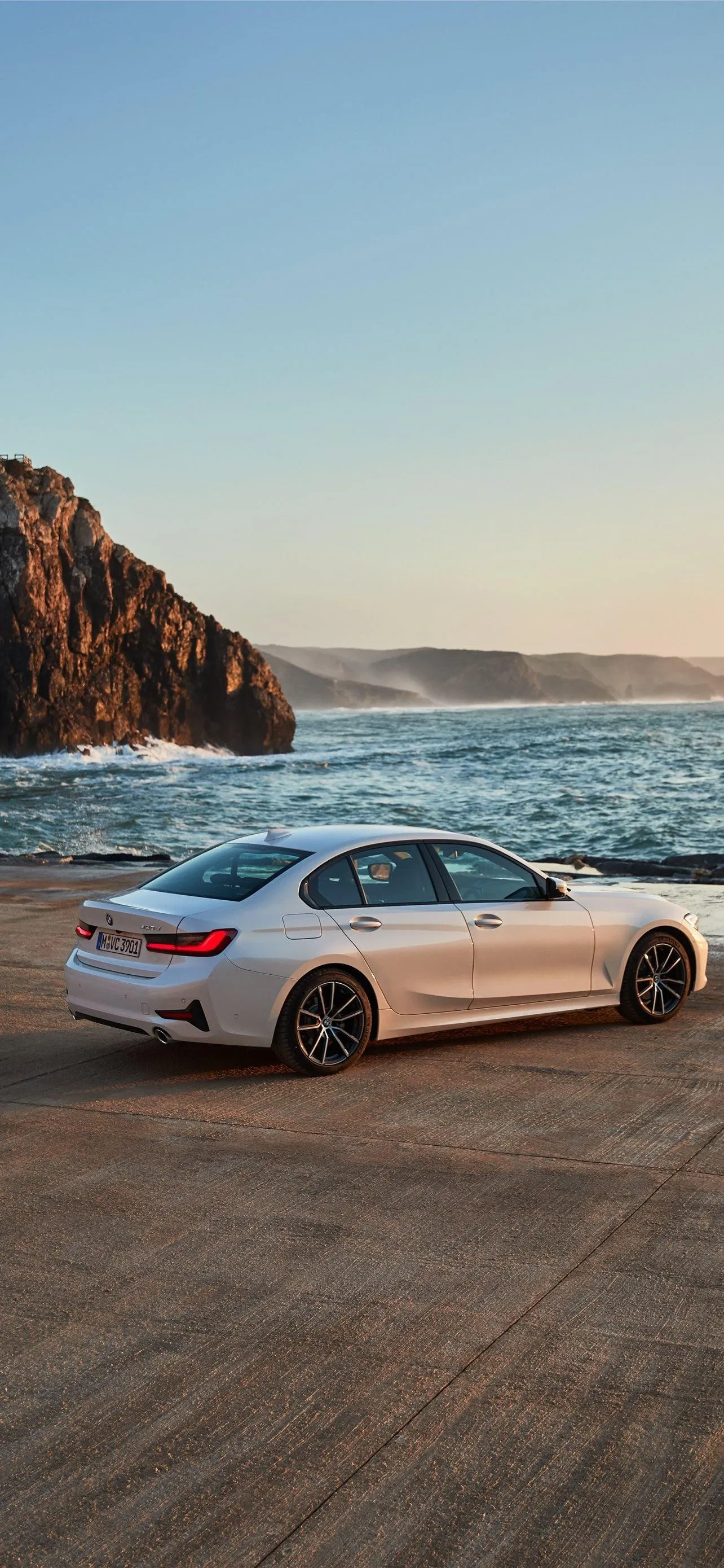 Bmw Parked By Ocean Cliffs at Golden Sunset Hour Wallpaper