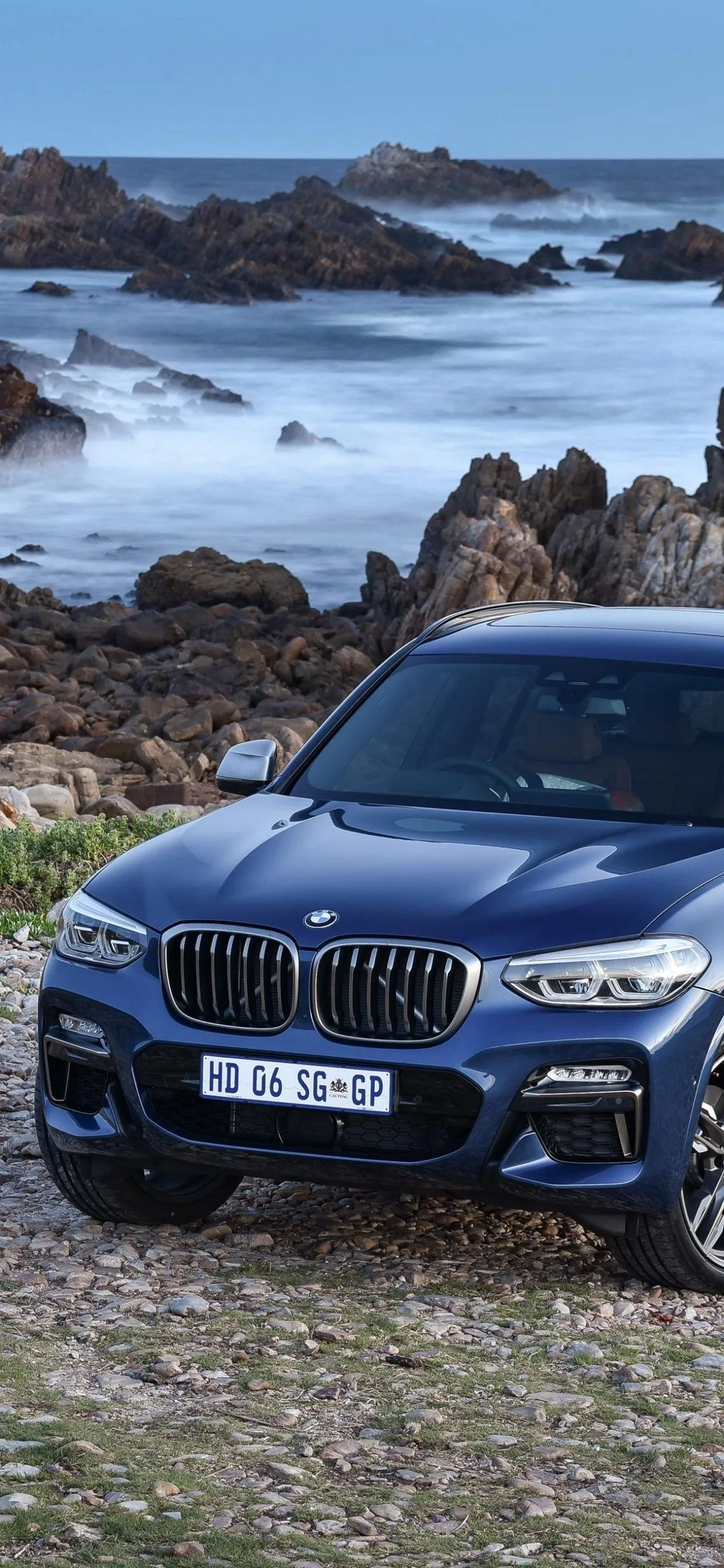 Bmw Parked By Rocky Coastline with Ocean in Background