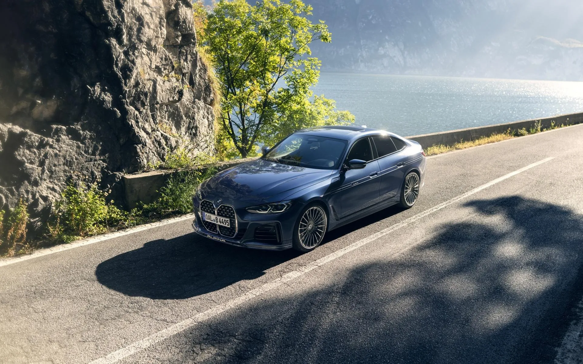 Bmw Parked Near Rock Cliffside Under Bright Blue Sky