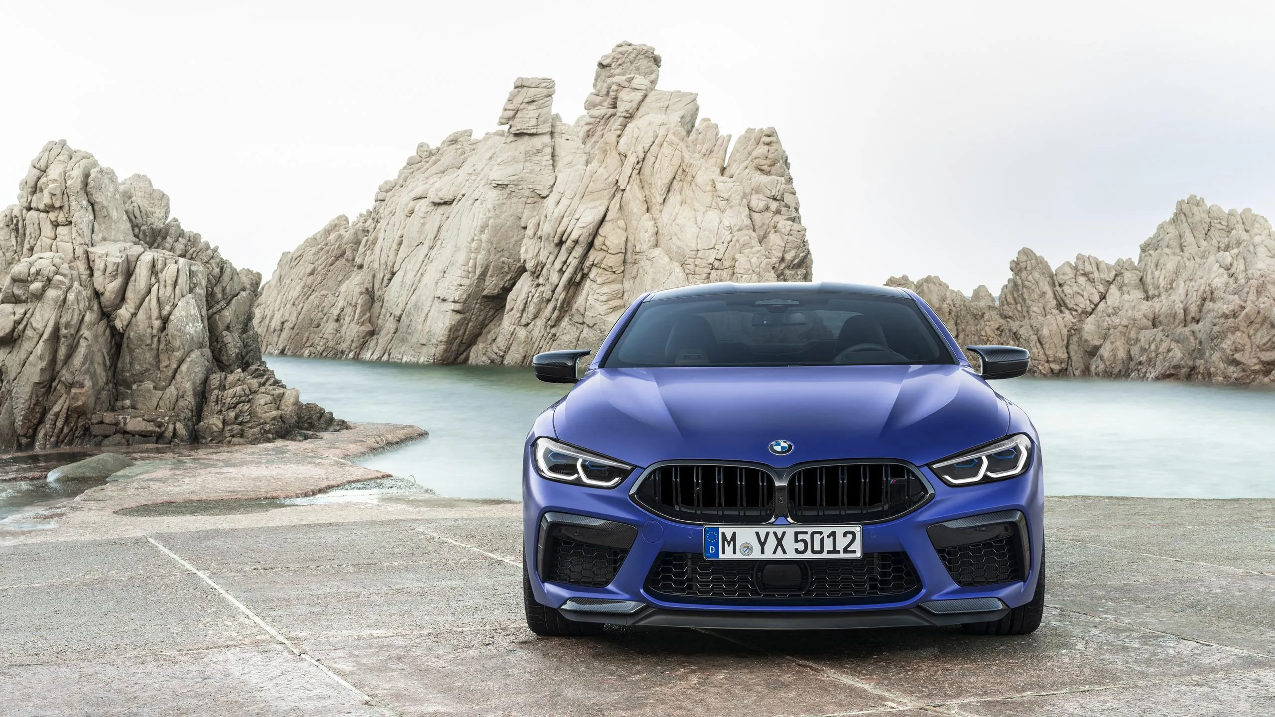 Bmw Parked on Beachside Road with Rocky Cliffs Behind
