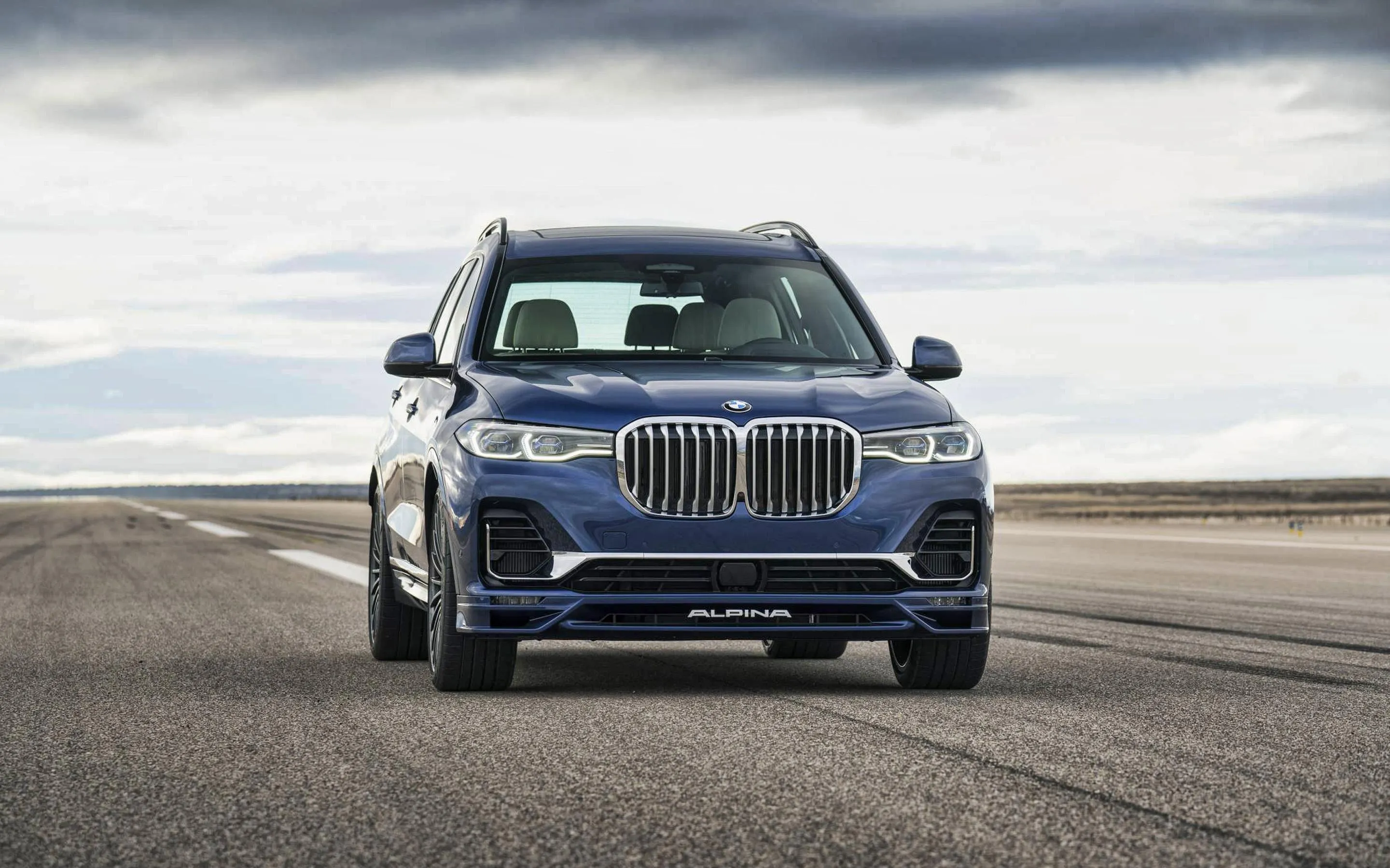 Bmw Parked on Wide Open Pavement with Cloudy Sky Above
