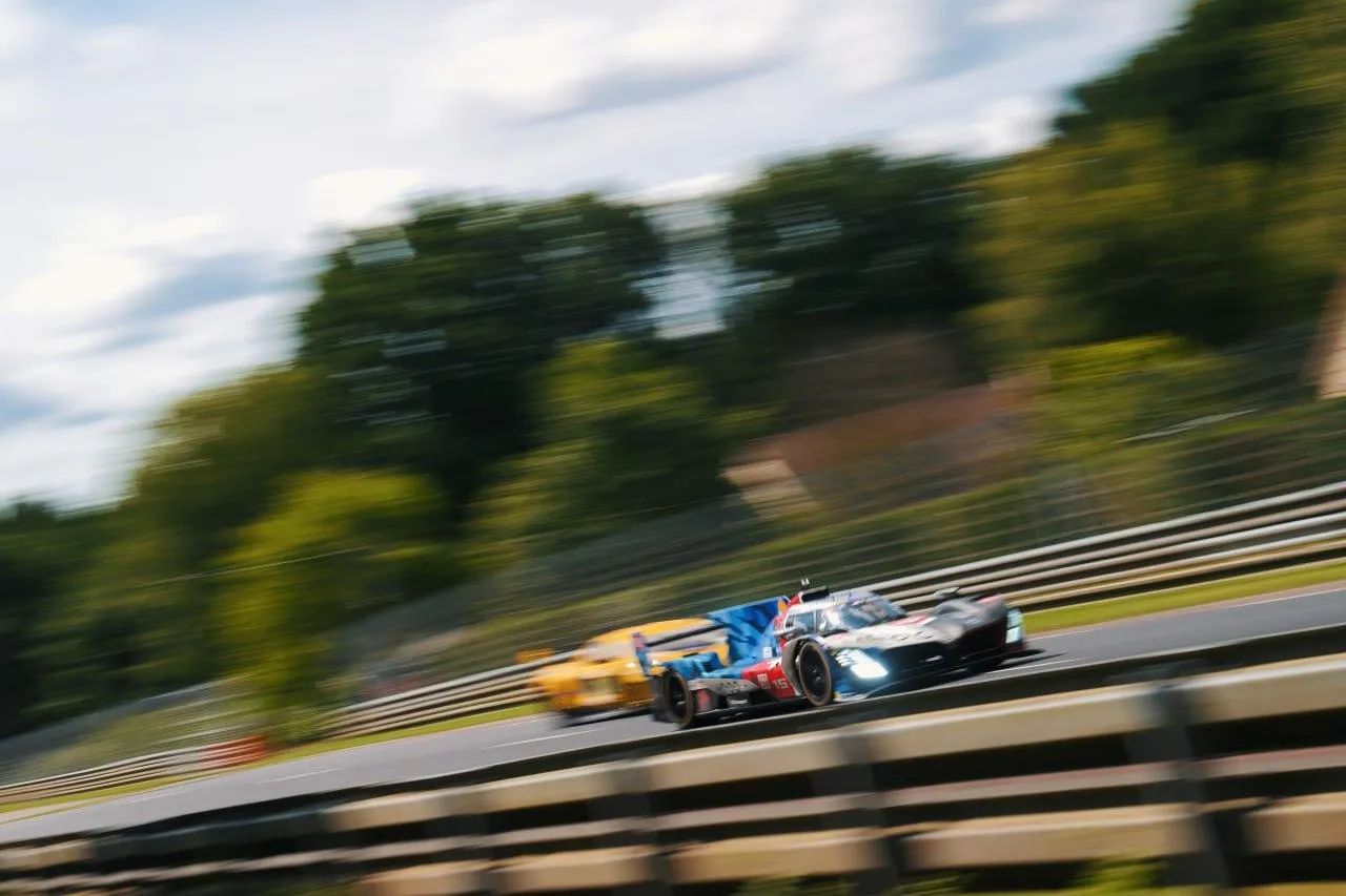 Bmw Race Car Speeding on Track with Trees in Background