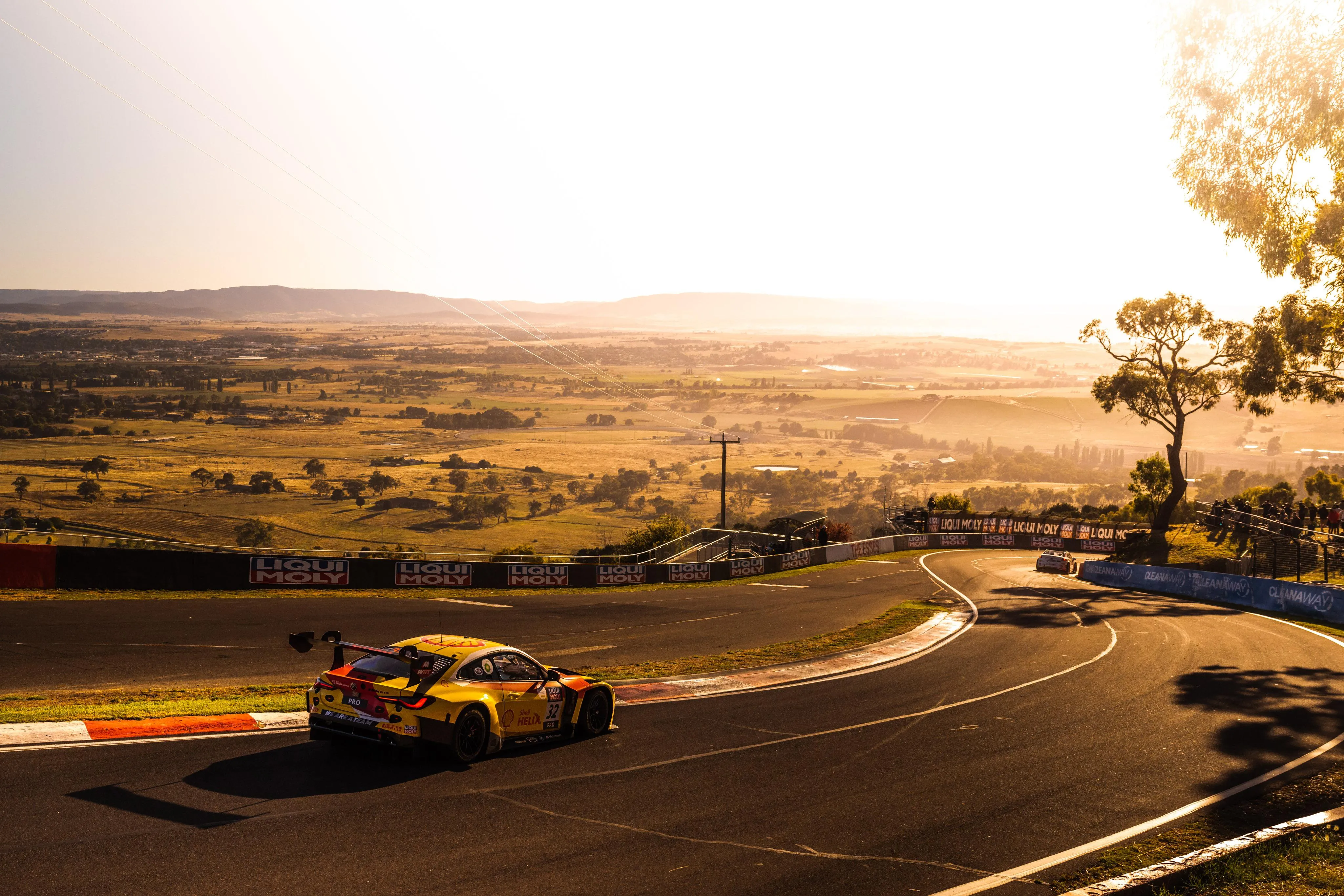 Bmw Race Car Taking Corner on Sunny Racetrack Wallpaper