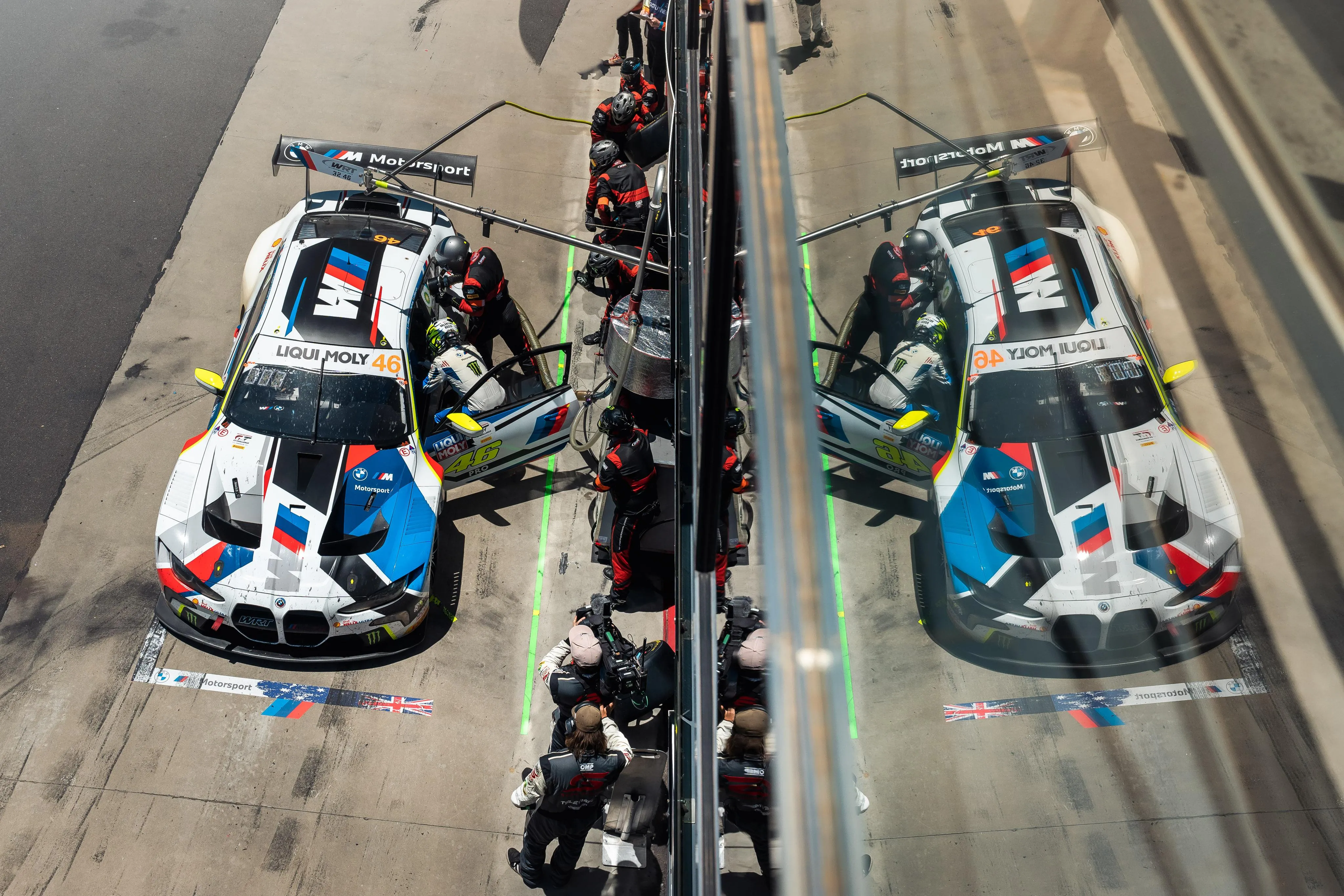 Bmw Race Cars at Pit Stop with Crew During Daytime Wallpaper