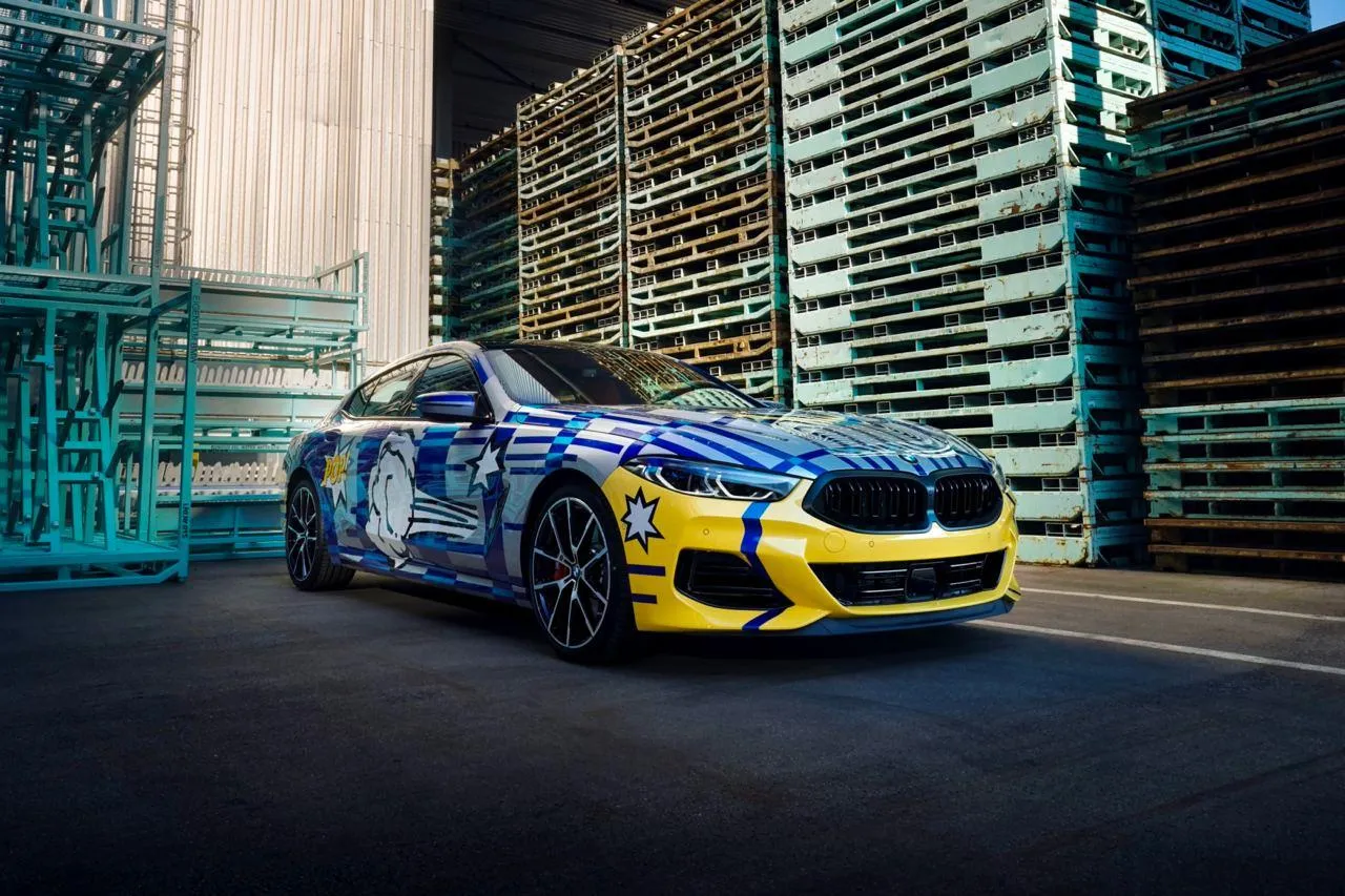 Bmw Racing Car Speeding Through Glass City District