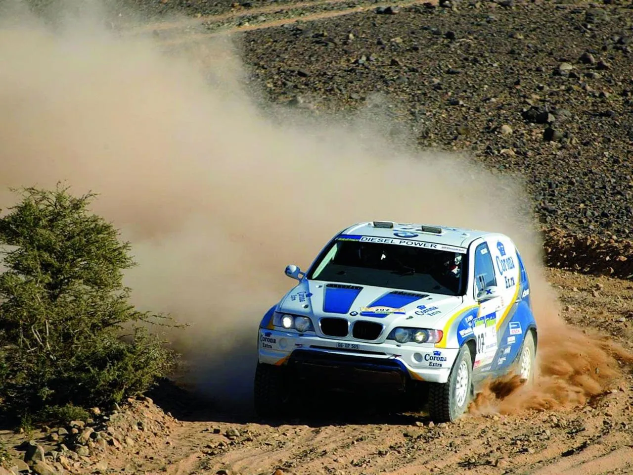 Bmw Rally Car Speeding Across an Off Road Track in a Desert