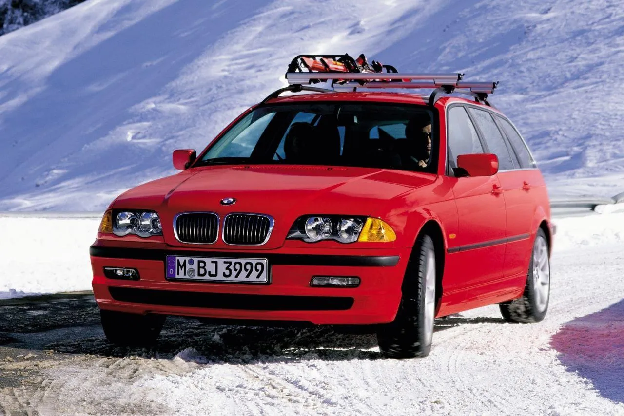 Bmw Red Car with Ski Equipment Driving in Snowy Area