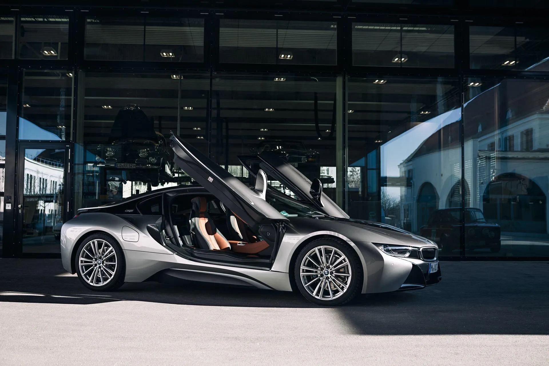 Bmw Roadster with Doors Open Parked in Front of Glass Building