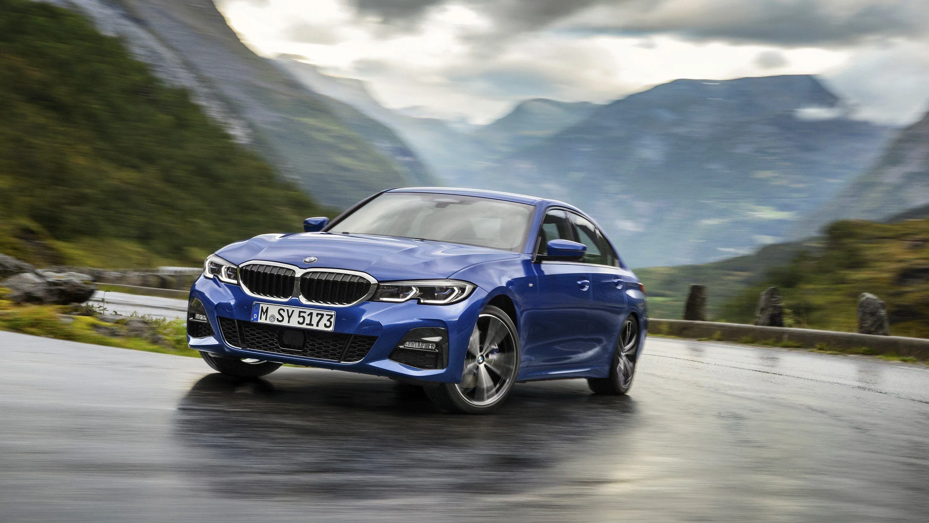 Bmw Sedan Driving Fast Through Mountain Scenery Wallpaper