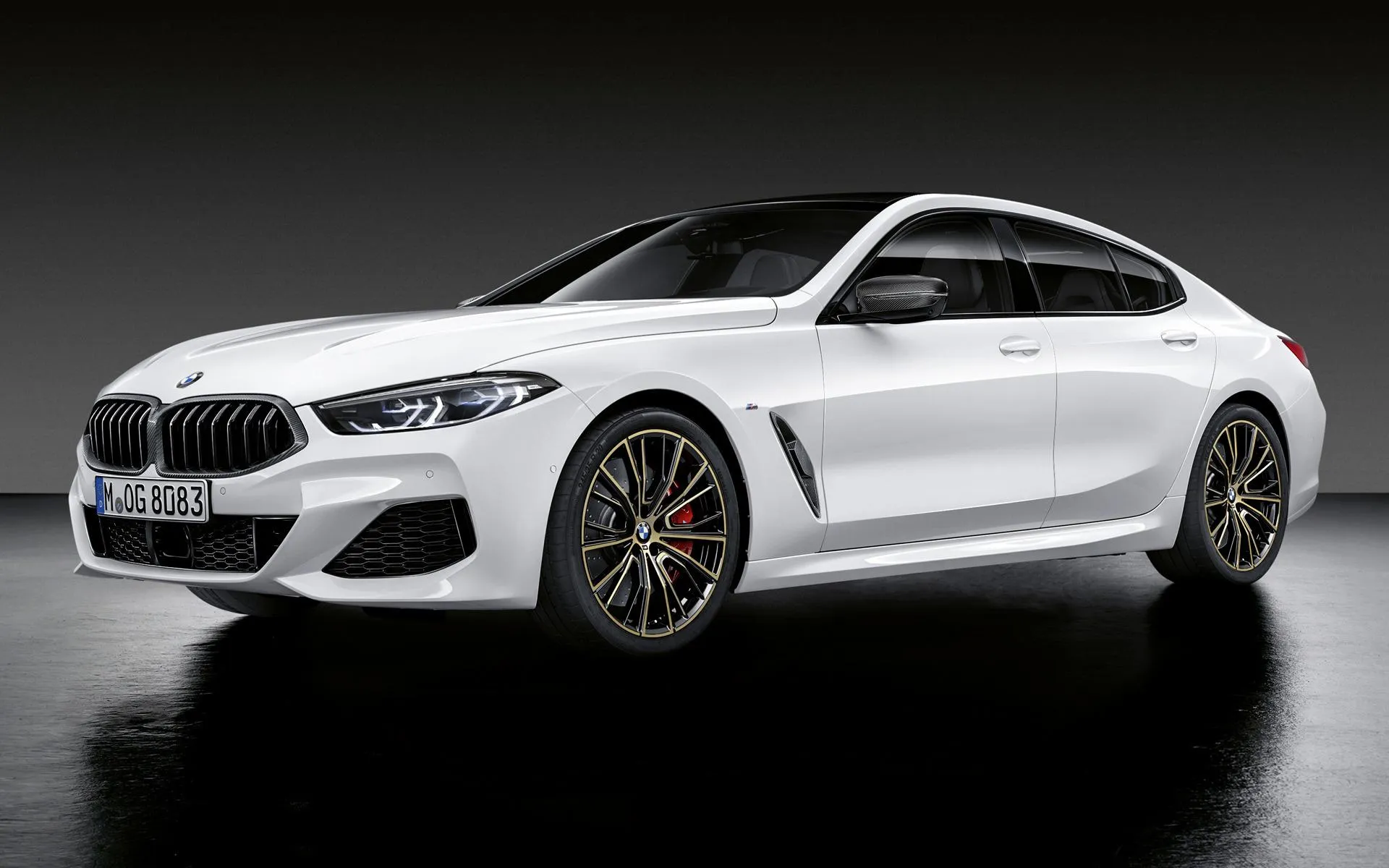 Bmw Sedan Driving on a Scenic Road with Windmills Wallpaper