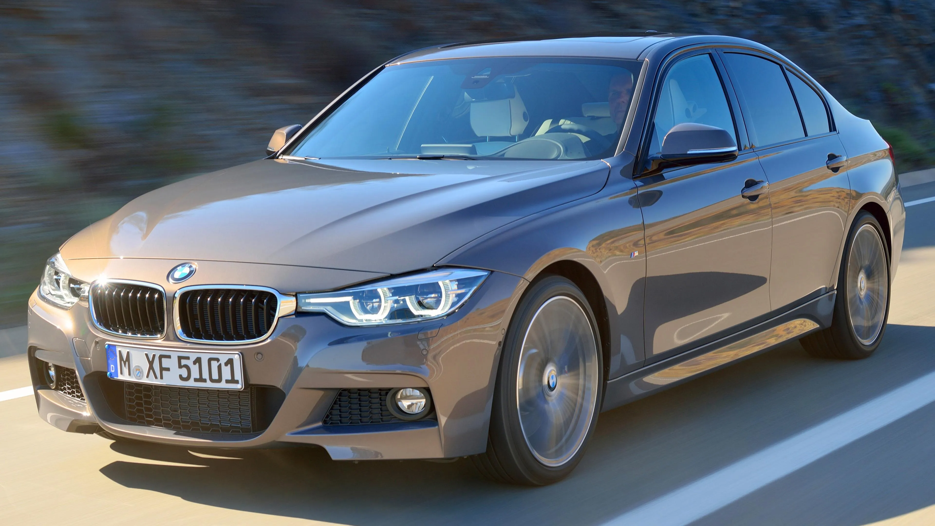 Bmw Sedan Driving on Open Road in Daylight 4K Wallpaper